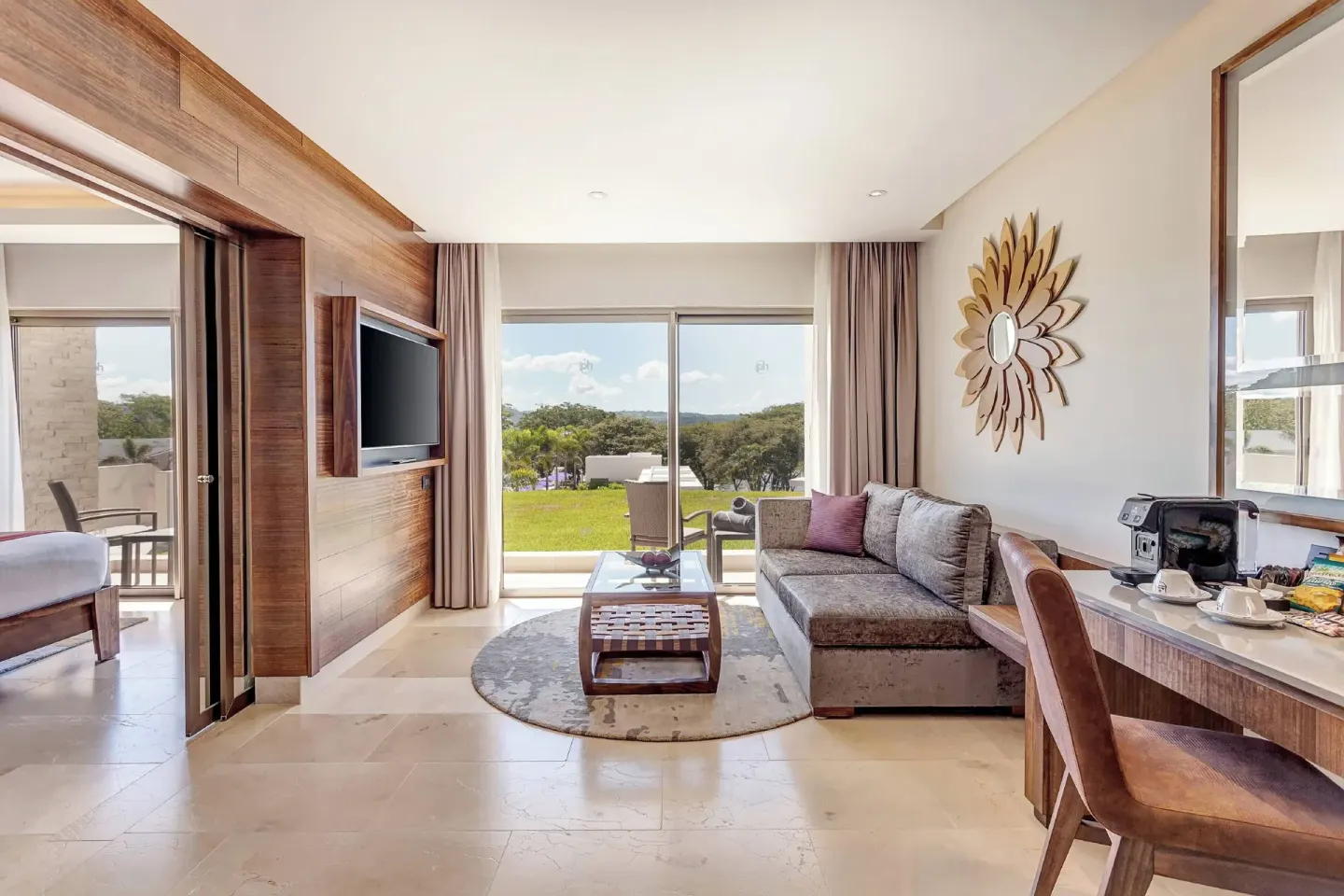 Suite living area with sofa, desk, and terrace at Planet Hollywood Costa Rica.