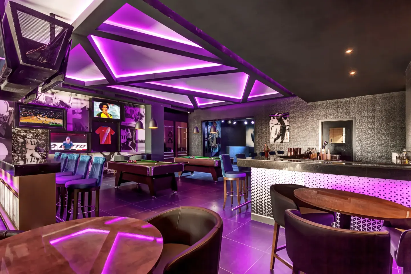 Purple-lit sports bar with pool tables at Planet Hollywood Costa Rica.