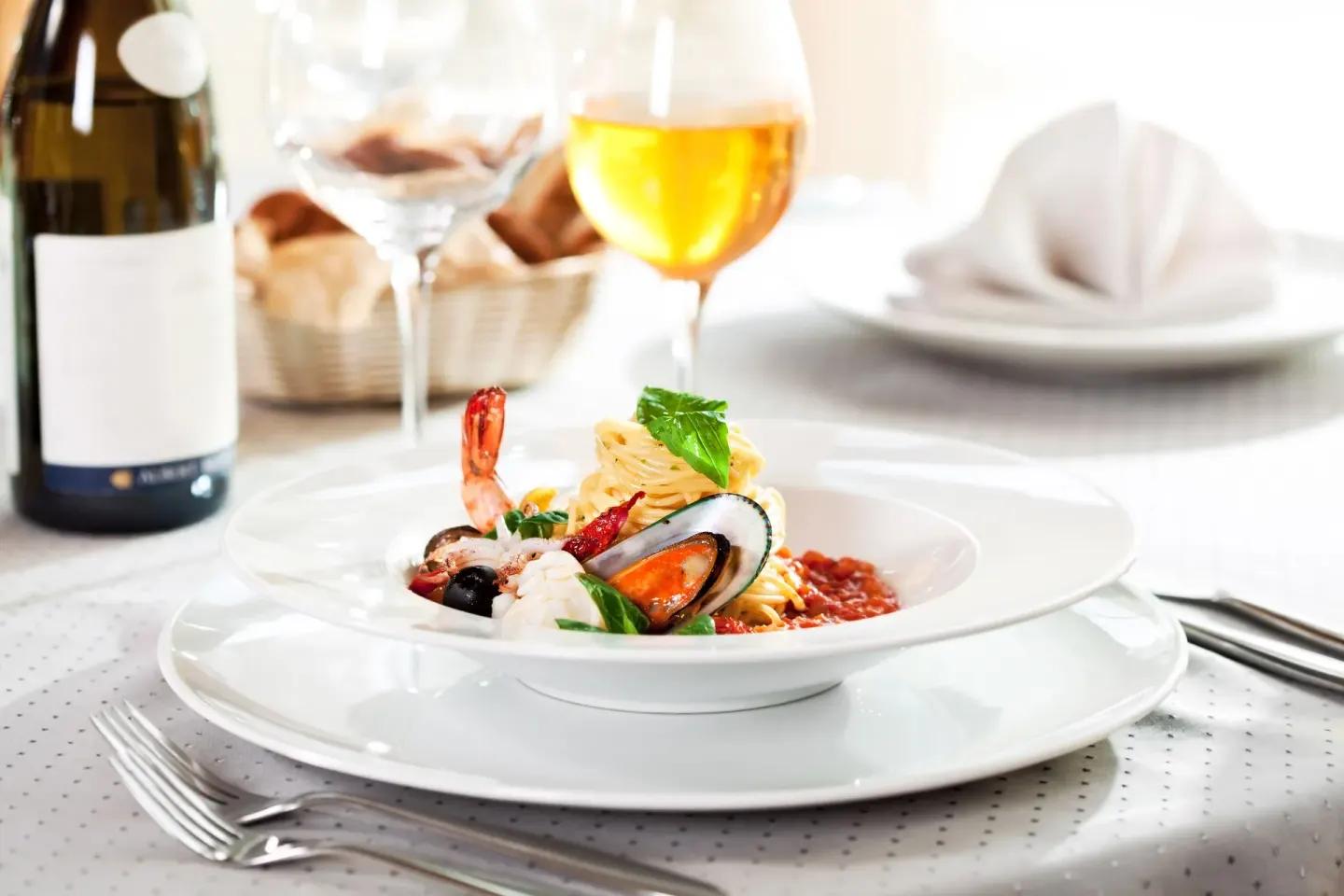 Seafood pasta with wine and table setting at Planet Hollywood Costa Rica.