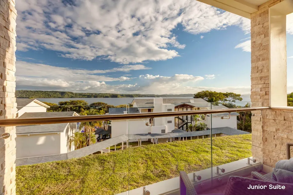 Junior Suite Ocean View balcony with bay and resort buildings at Planet Hollywood Costa Rica.