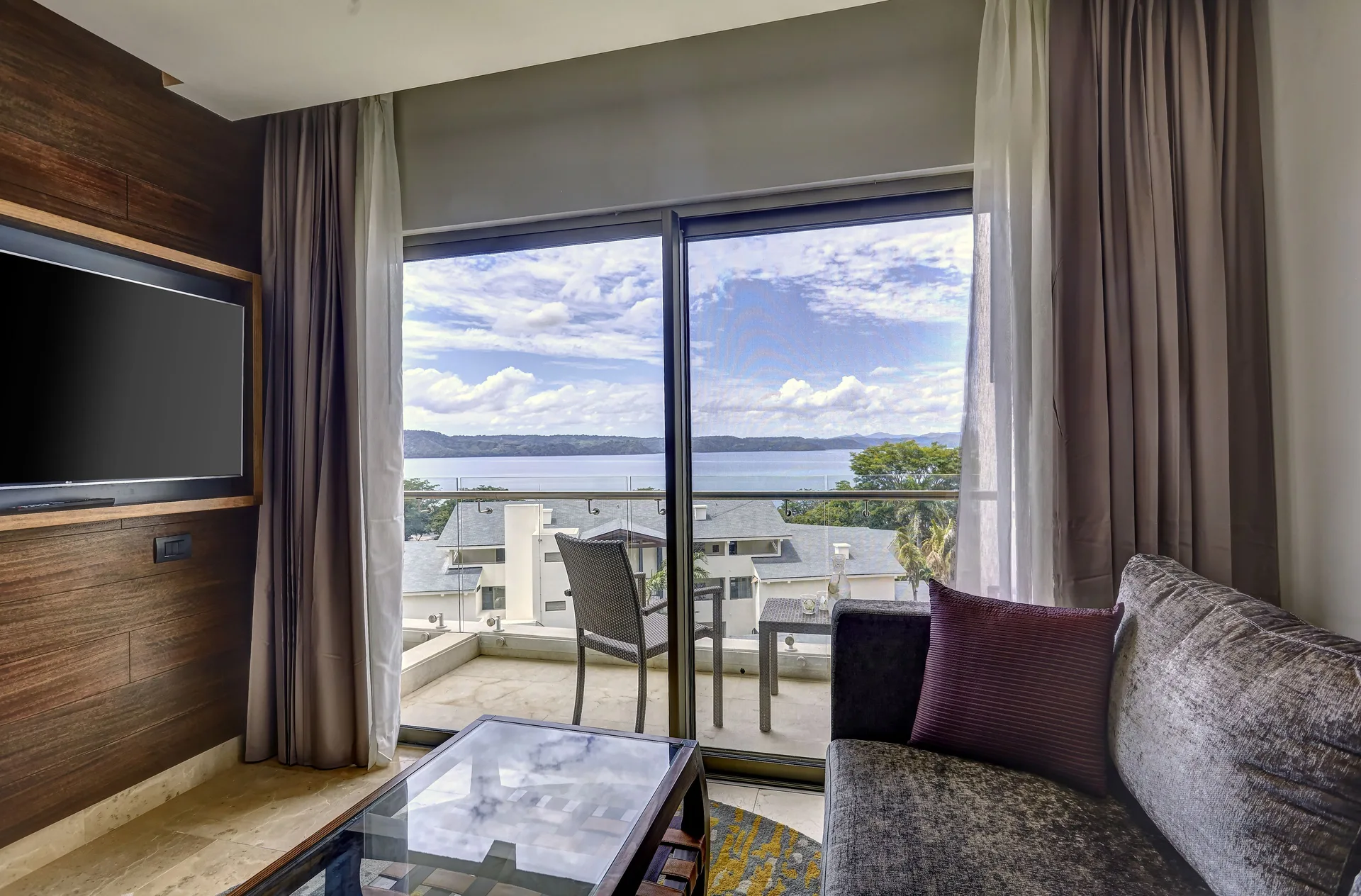 Junior Suite Ocean View lounge with TV and balcony at Planet Hollywood Costa Rica.