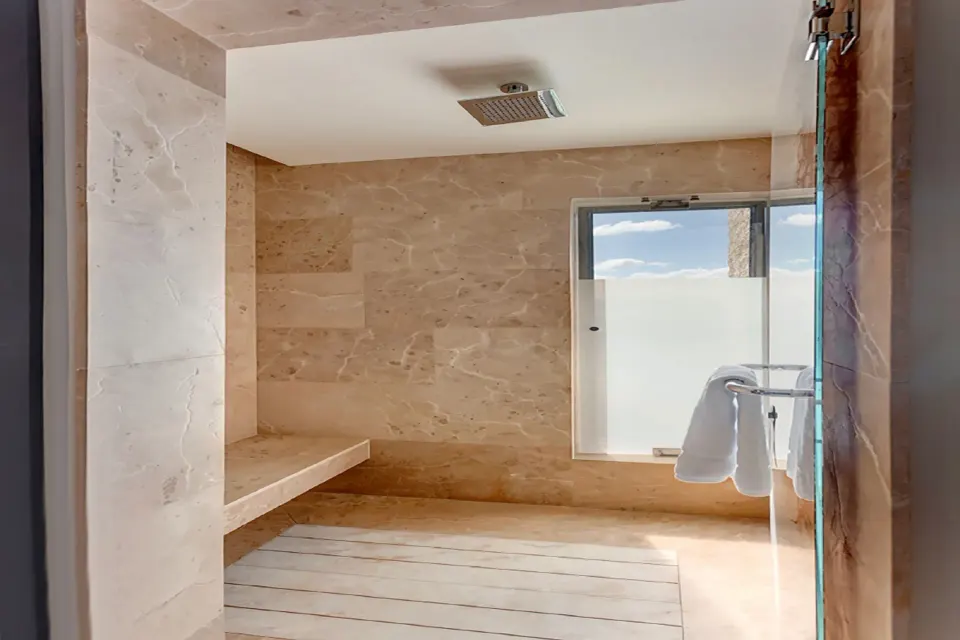 Junior Suite walk-in shower with stone walls at Planet Hollywood Costa Rica.