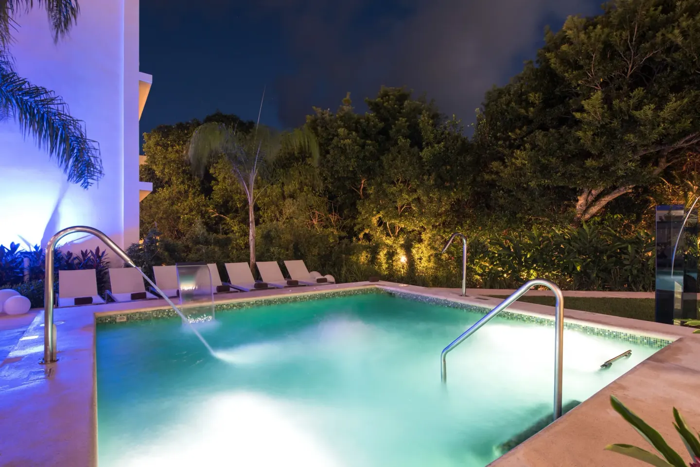 Illuminated small pool with water jets and loungers at Platinum Yucatan Princess.