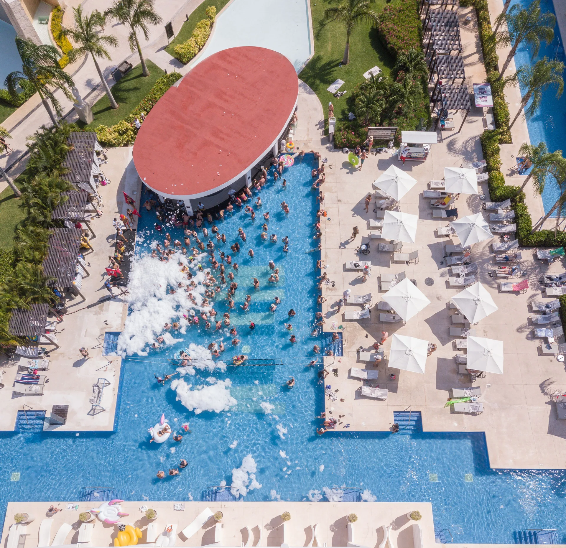 Aerial view of a lively pool with guests and foam at Platinum Yucatan Princess.