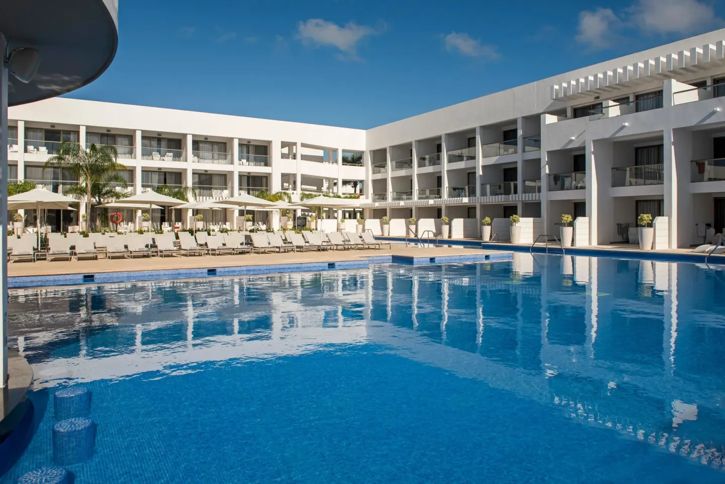 Large pool surrounded by white guest room buildings at Platinum Yucatan Princess.