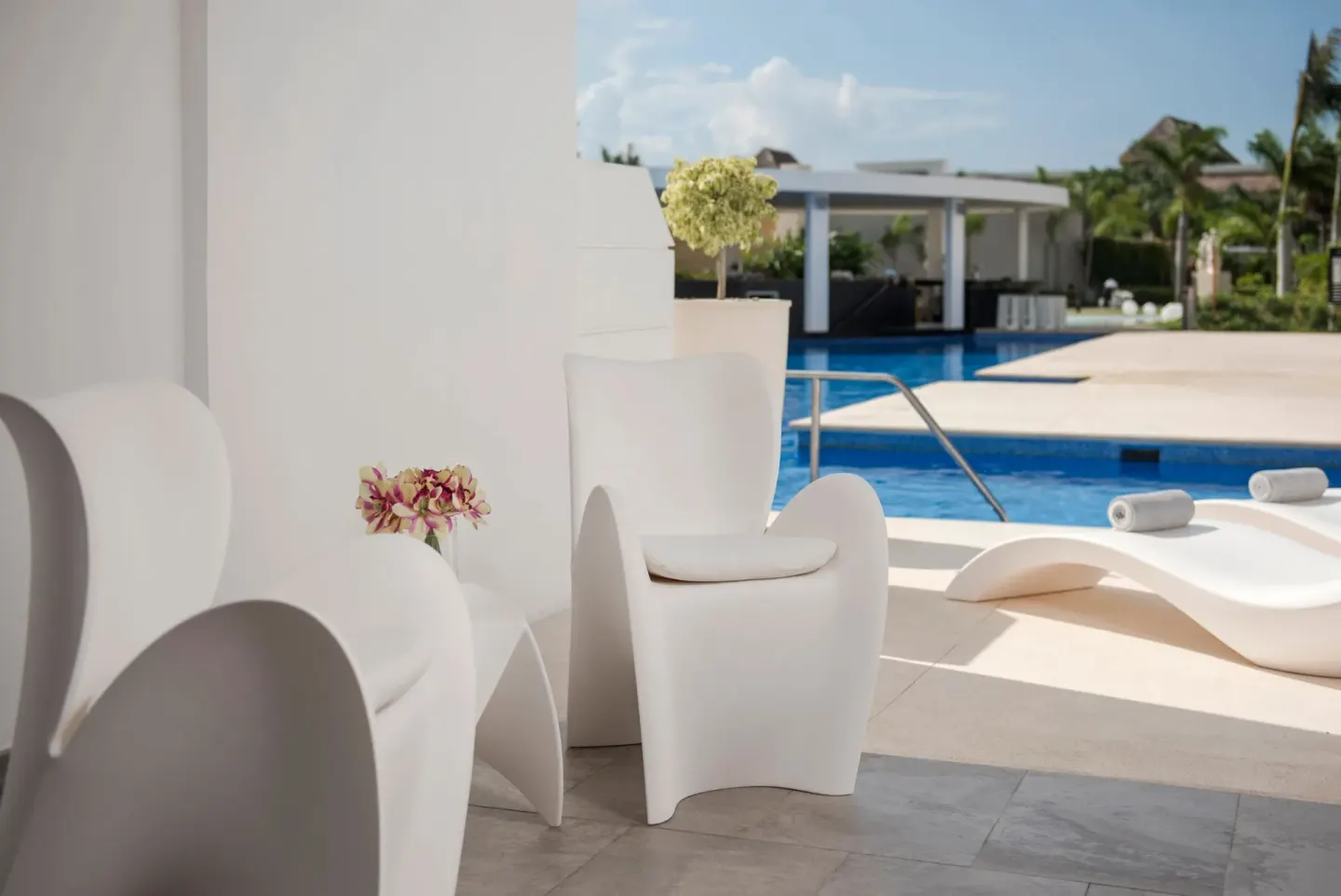 White lounge chairs beside a pool at Platinum Yucatan Princess.