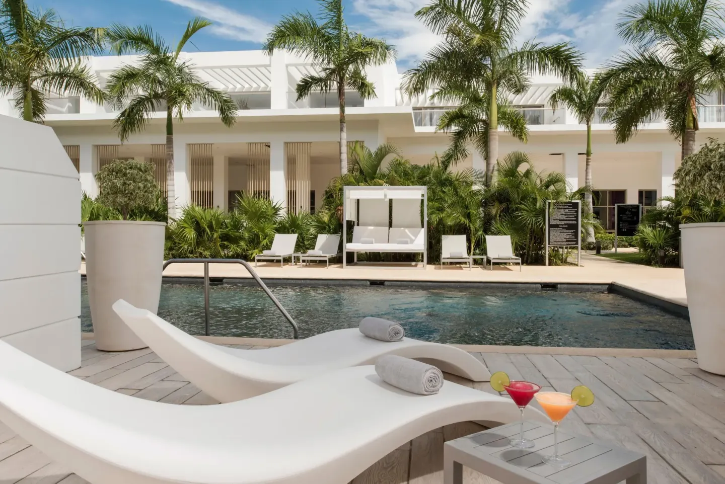 White loungers with towels beside a pool at Platinum Yucatan Princess.