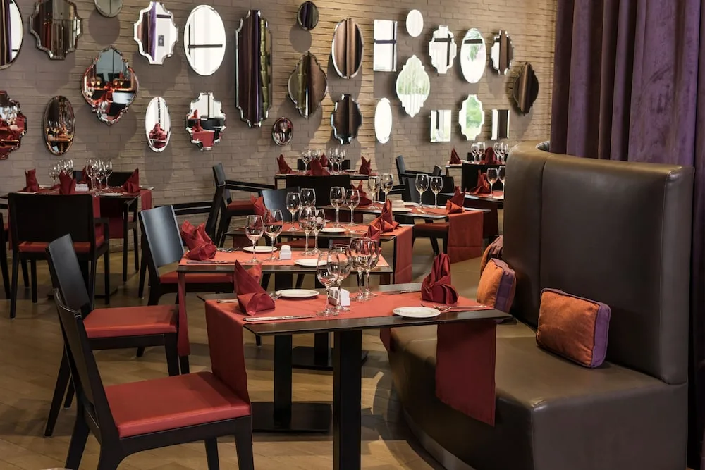 Red-accented restaurant dining room with mirror wall decor at Platinum Yucatan Princess.