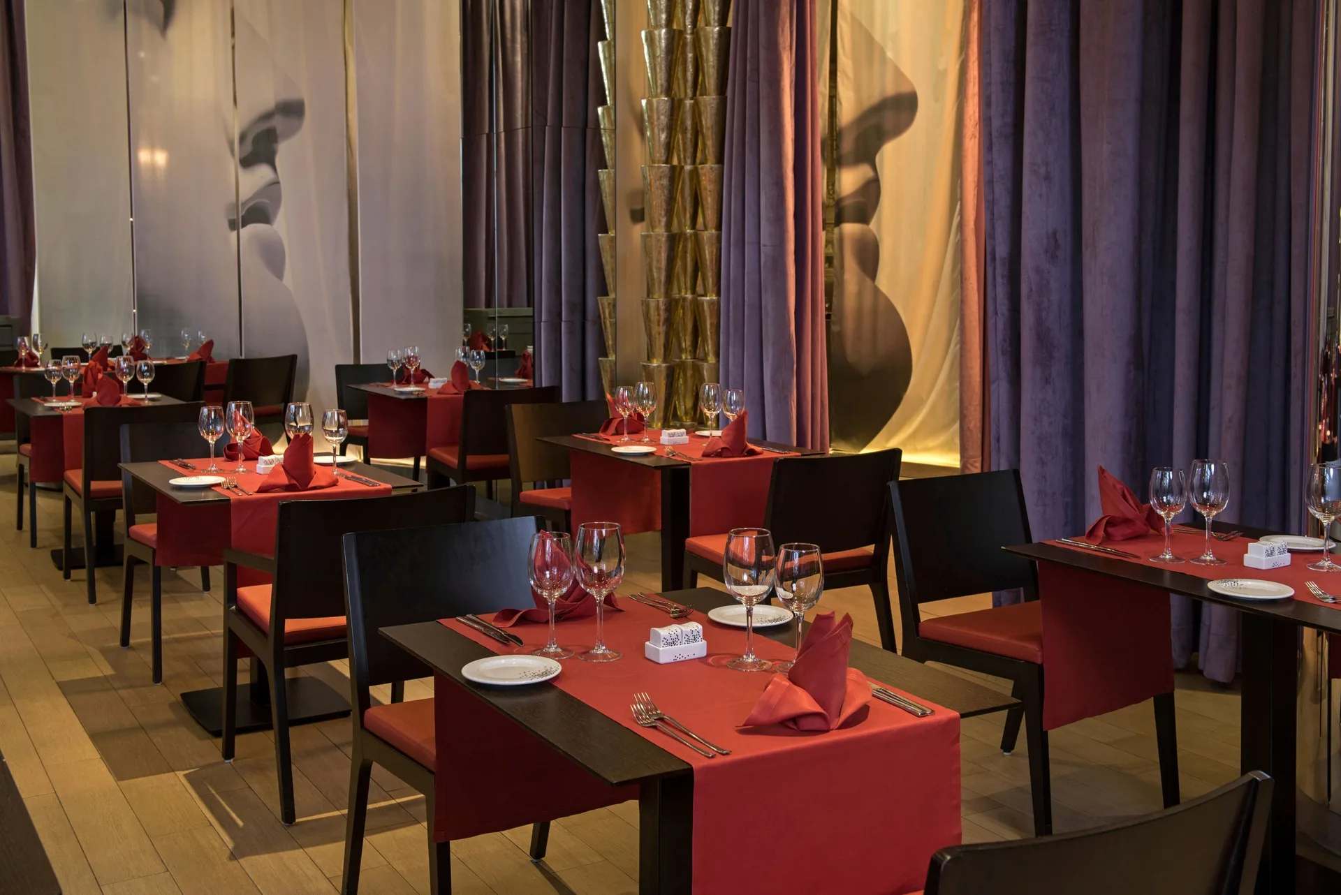 Red table settings in a softly lit restaurant at Platinum Yucatan Princess.