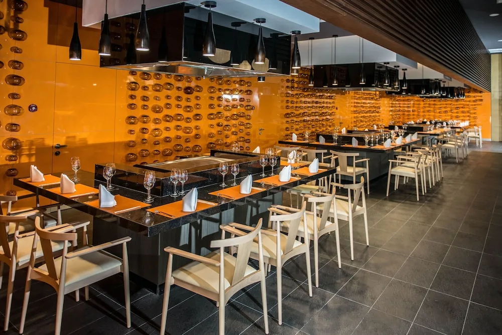 Teppanyaki-style dining counters with orange wall accents at Platinum Yucatan Princess.