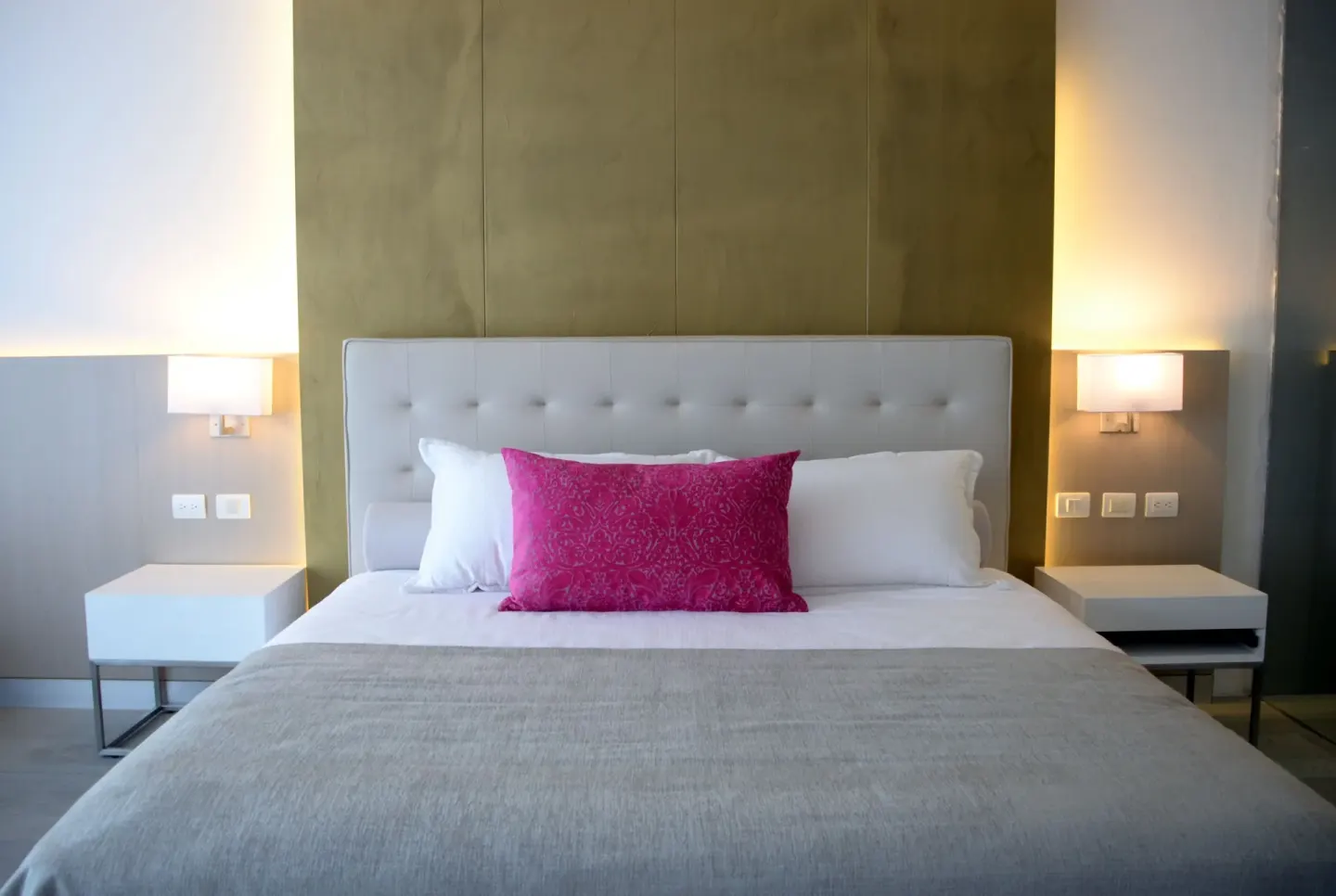 Deluxe Room king bed with pink accent pillow at Platinum Yucatan Princess