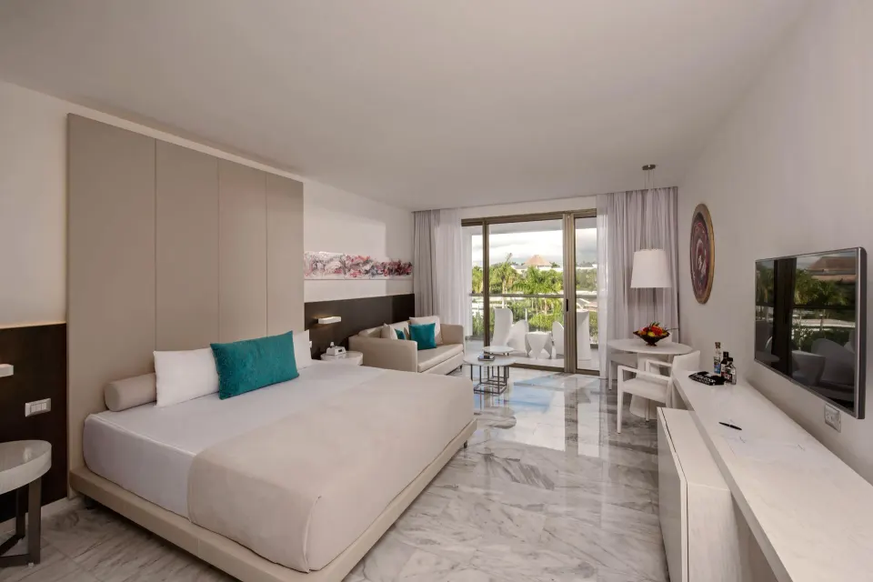 Junior Suite with king bed, sofa, balcony, and TV at Platinum Yucatan Princess.
