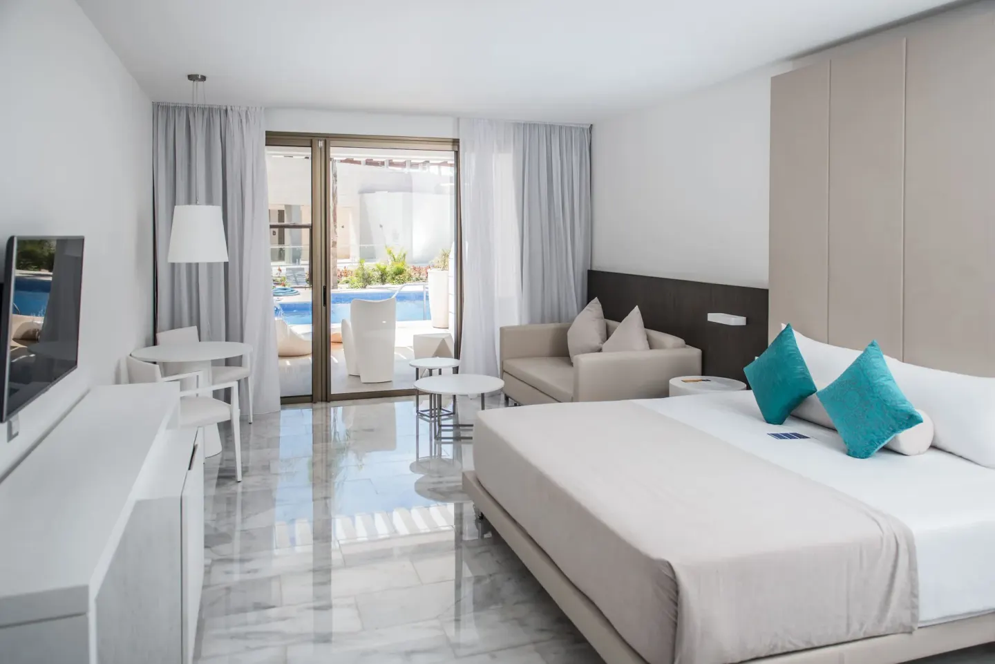 Swim-out room with king bed and sliding doors to the pool terrace at Platinum Yucatan Princess.