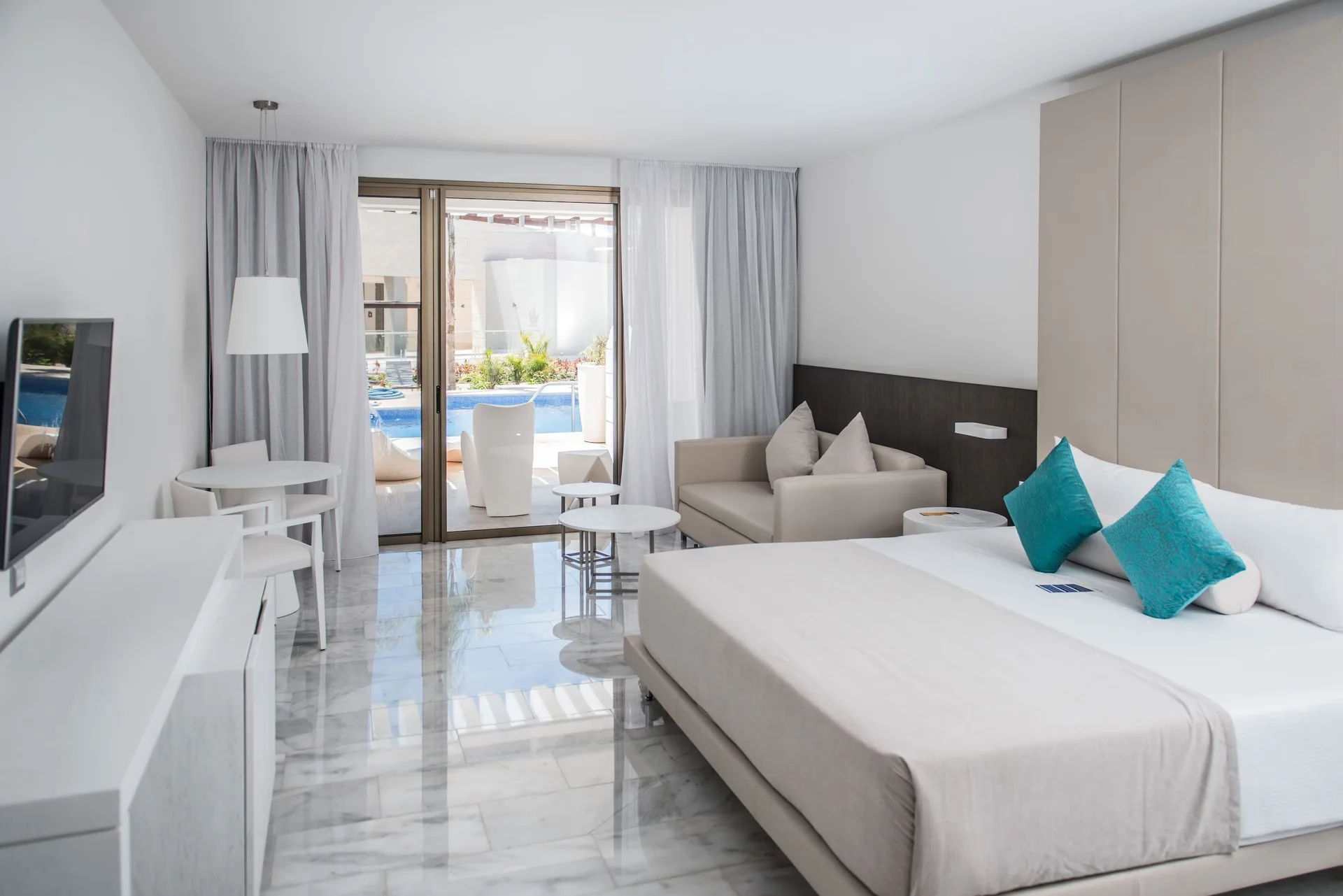 Honeymoon Suite Swimout at Platinum Yucatan Princess with king bed, modern design, and direct swim-out pool access from the terrace.