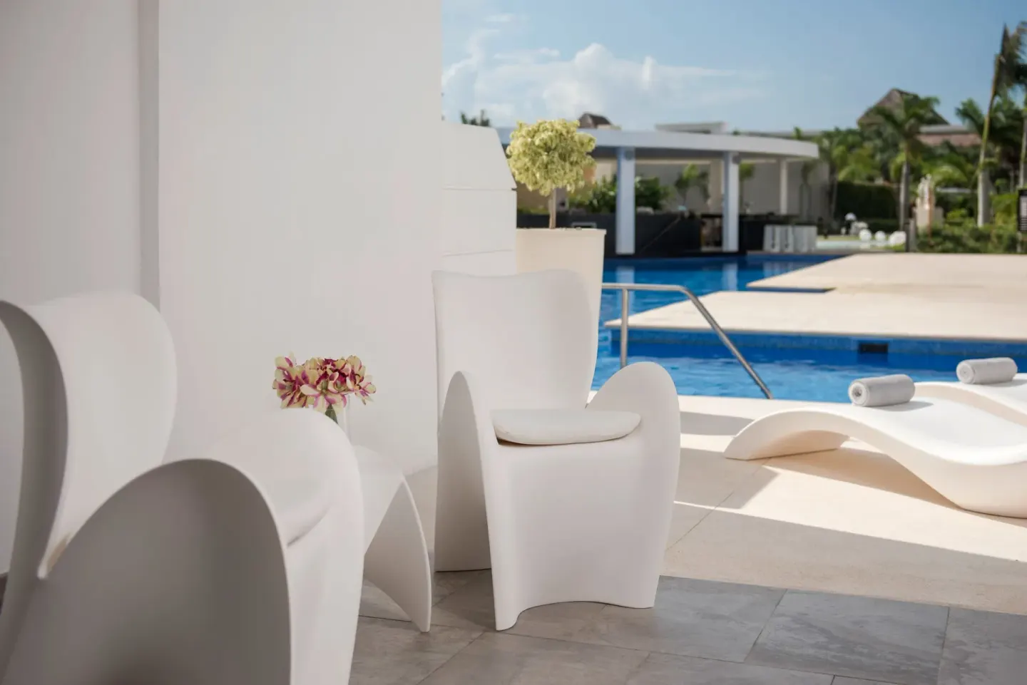 Pool access patio with white seating and loungers at Platinum Yucatan Princess.