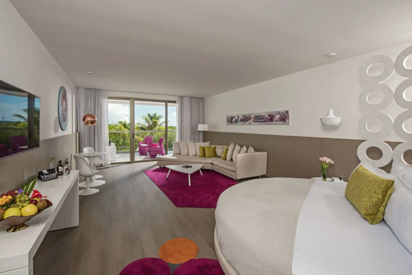 Round bed suite with sofa, TV, balcony, and pink accents at Platinum Yucatan Princess.