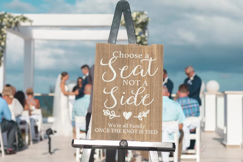 Wedding ceremony sign and seated guests by the sea at Platinum Yucatan Princess.