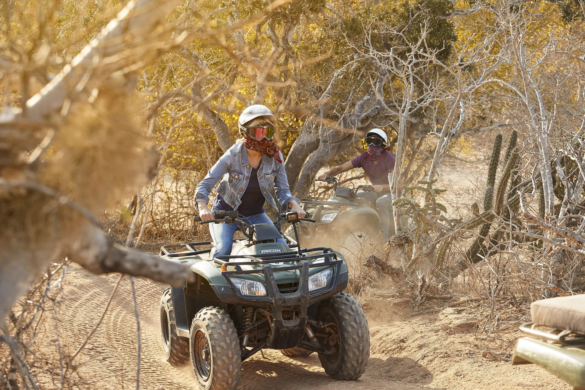 Guests riding ATVs on a dusty trail near Playa Grande Resort & Grand Spa.