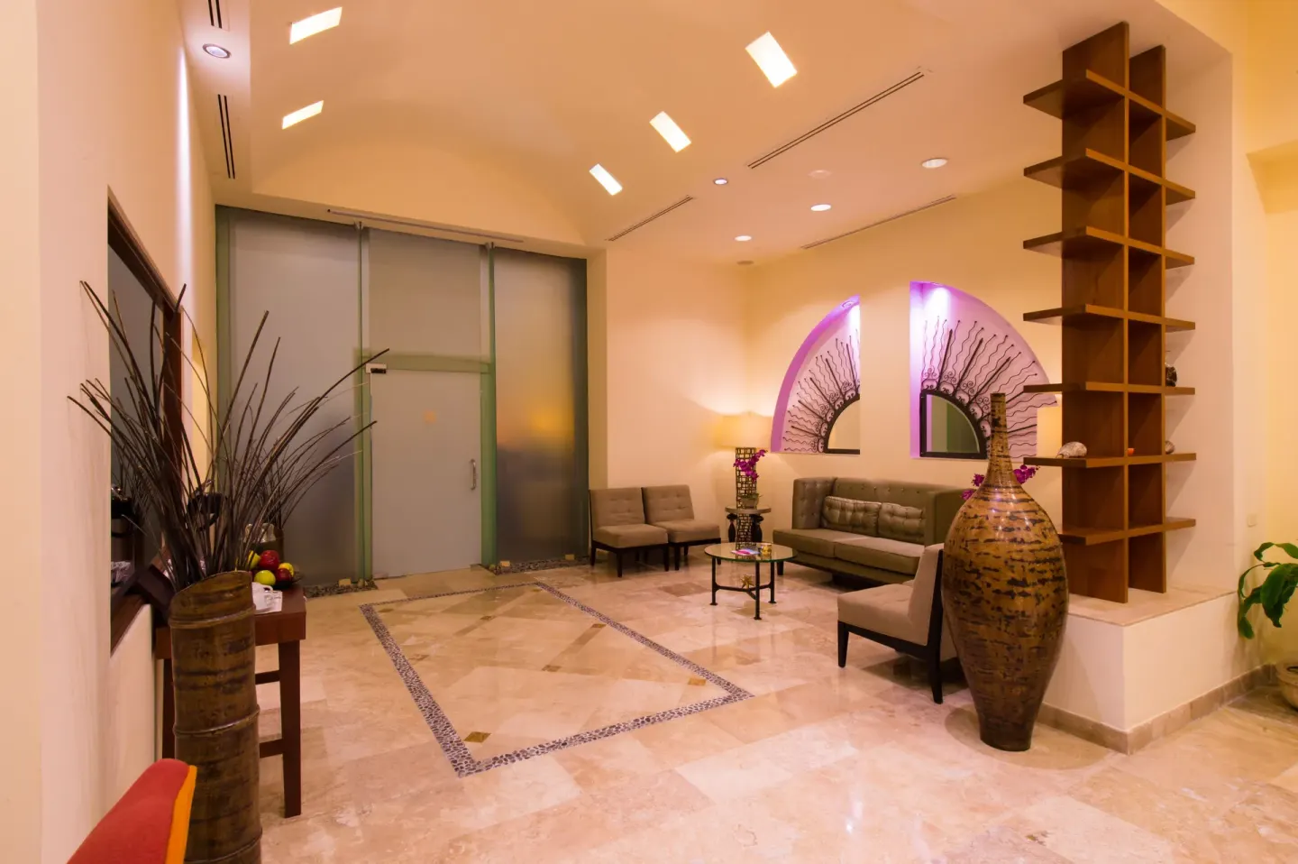 Lobby seating area with frosted glass doors at Playa Grande Resort & Grand Spa.