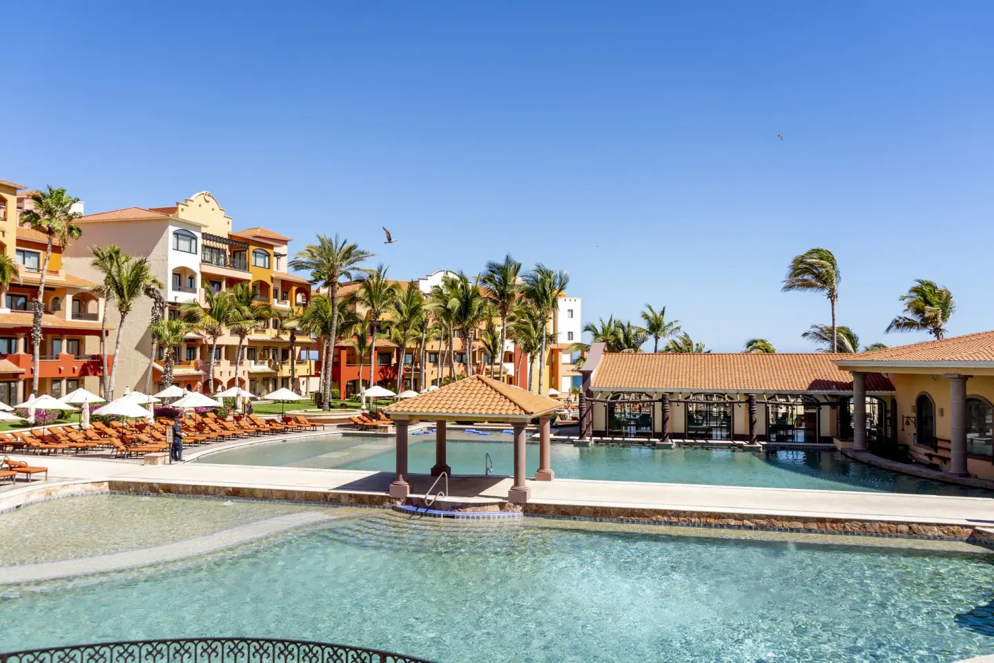 Wide pool area with palms and resort buildings at Playa Grande Resort & Grand Spa.