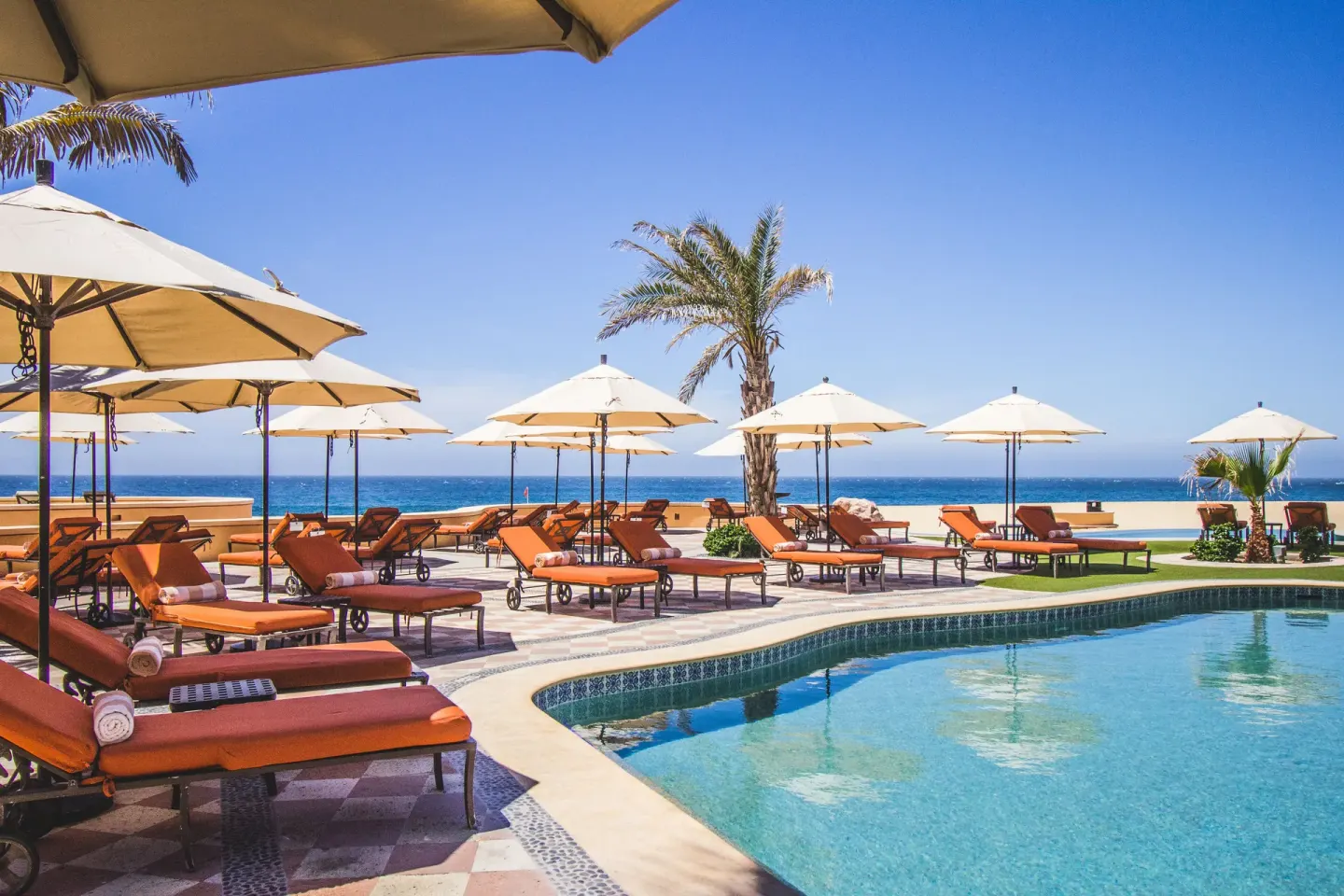 Oceanfront pool deck with loungers and umbrellas at Playa Grande Resort & Grand Spa.