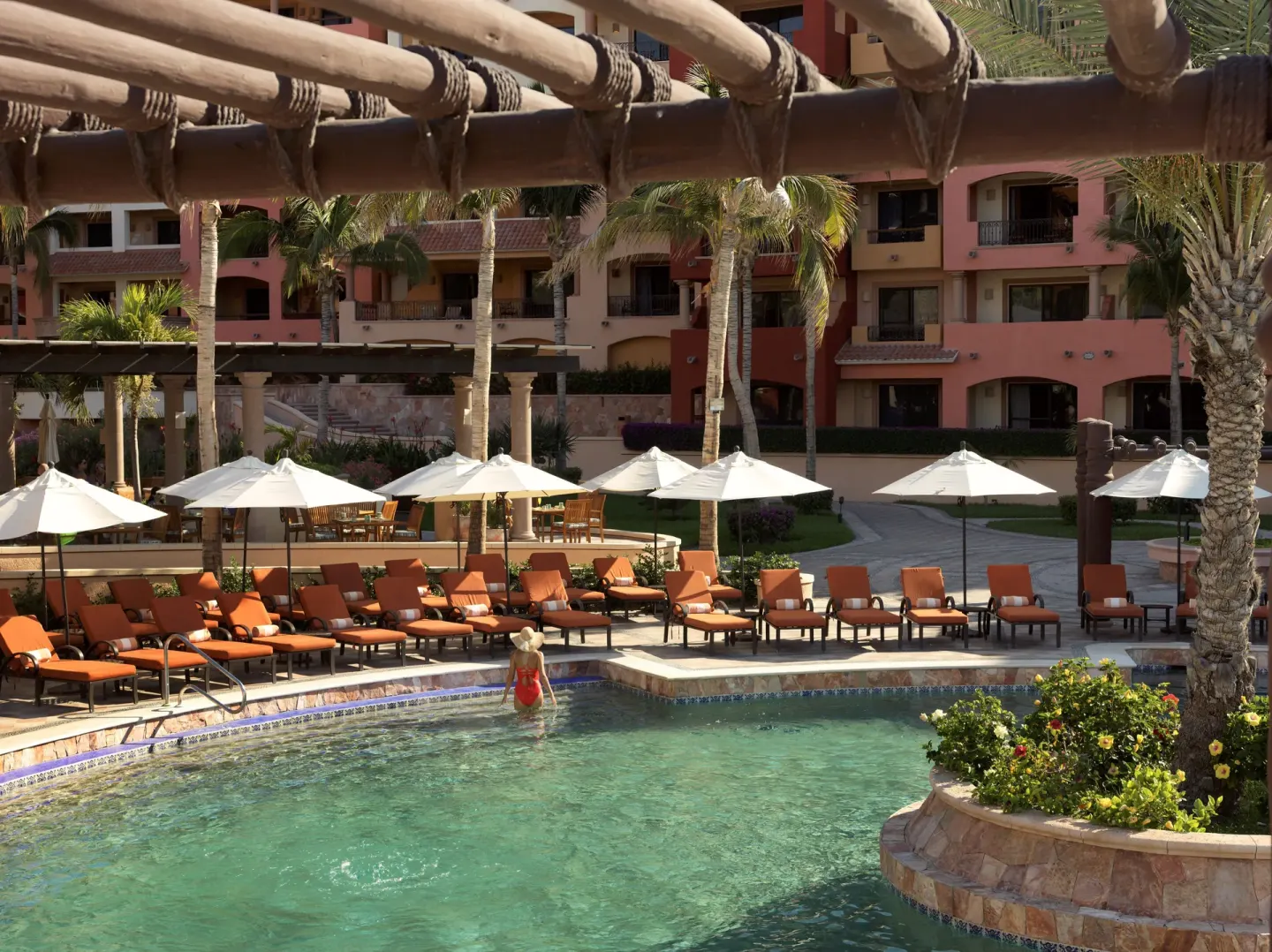 Pool with orange loungers under white umbrellas at Playa Grande Resort & Grand Spa.