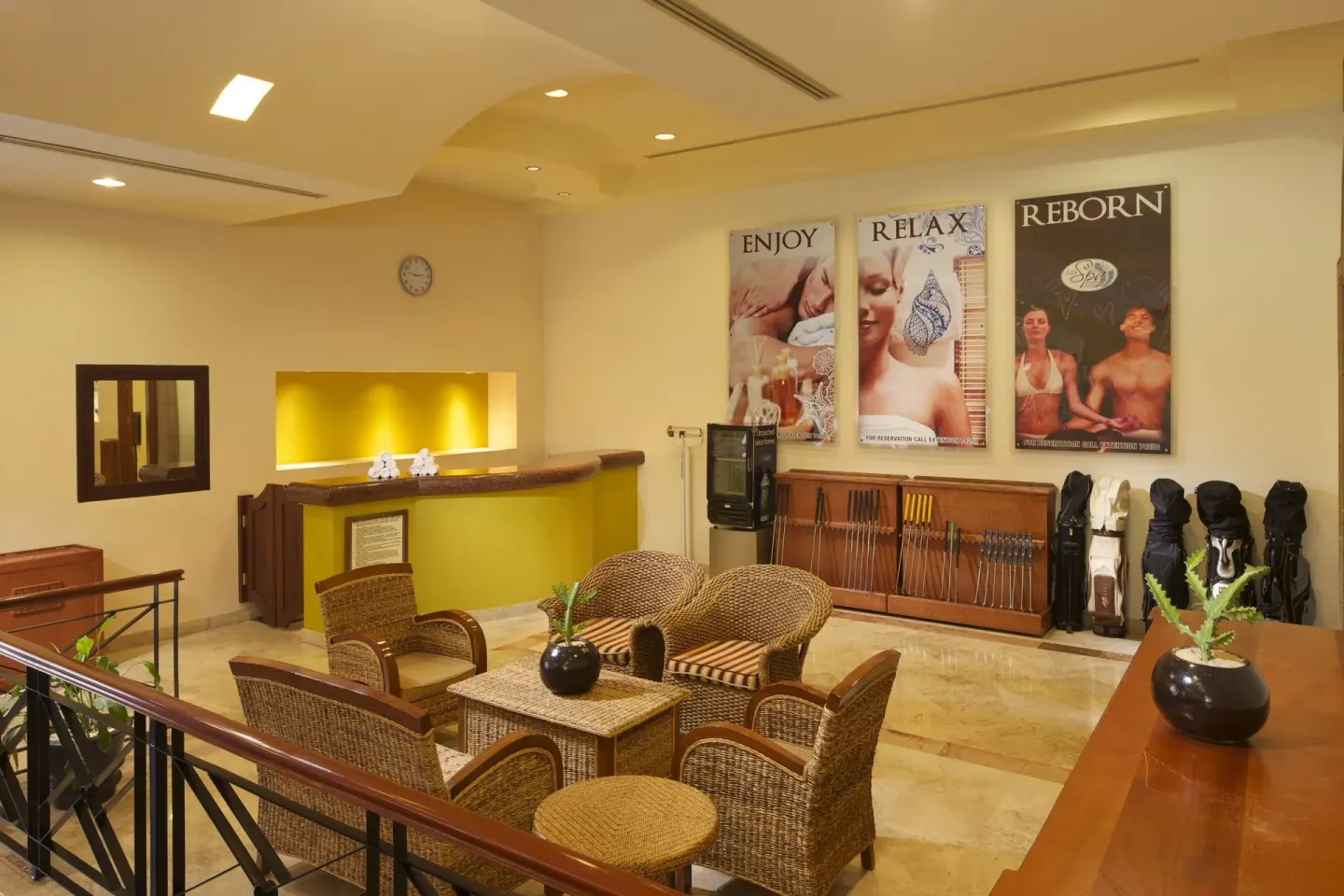 Spa reception lounge with wicker seating and golf equipment at Playa Grande Resort & Grand Spa.