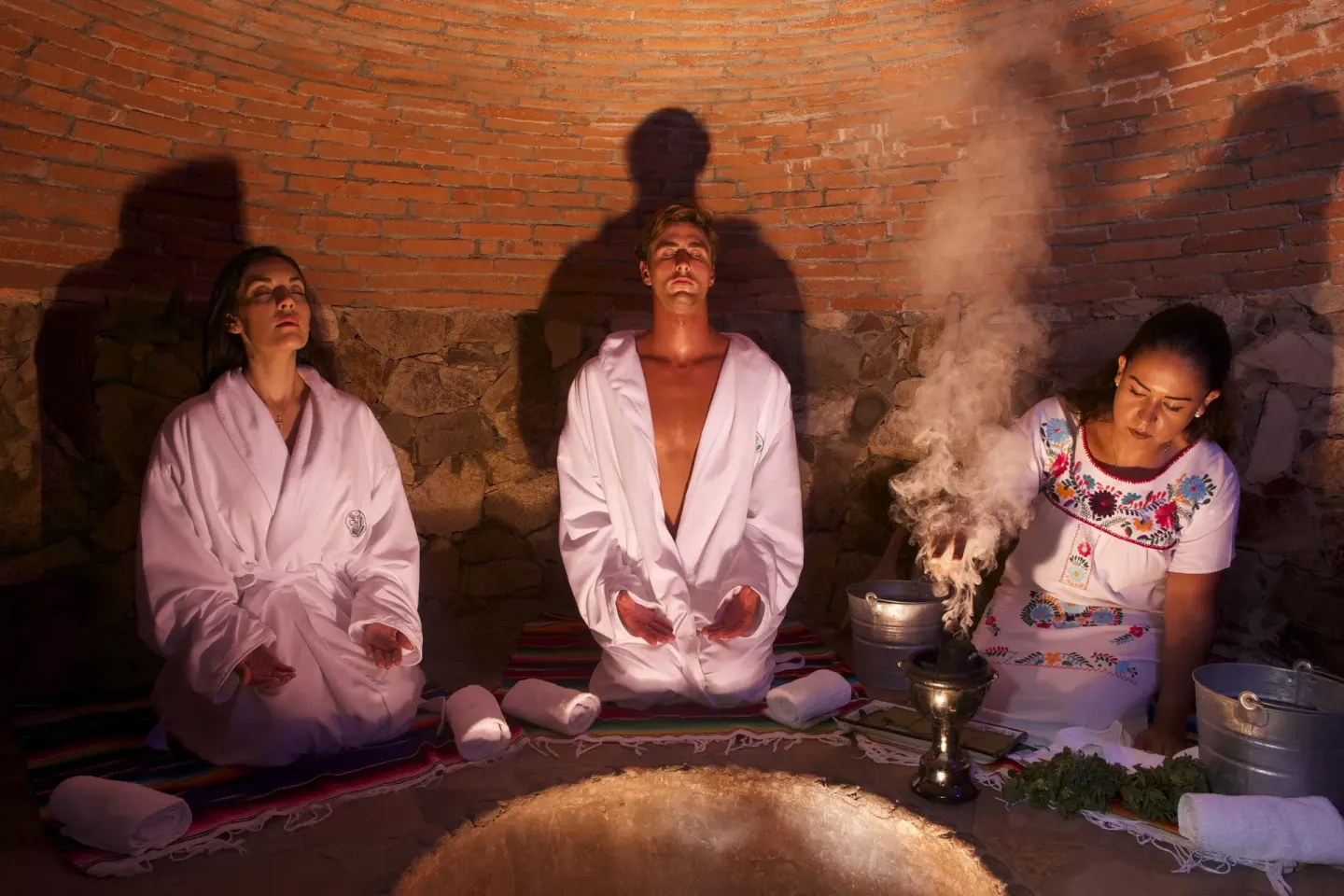 Spa ritual with guests in robes inside a brick chamber at Playa Grande Resort & Grand Spa.