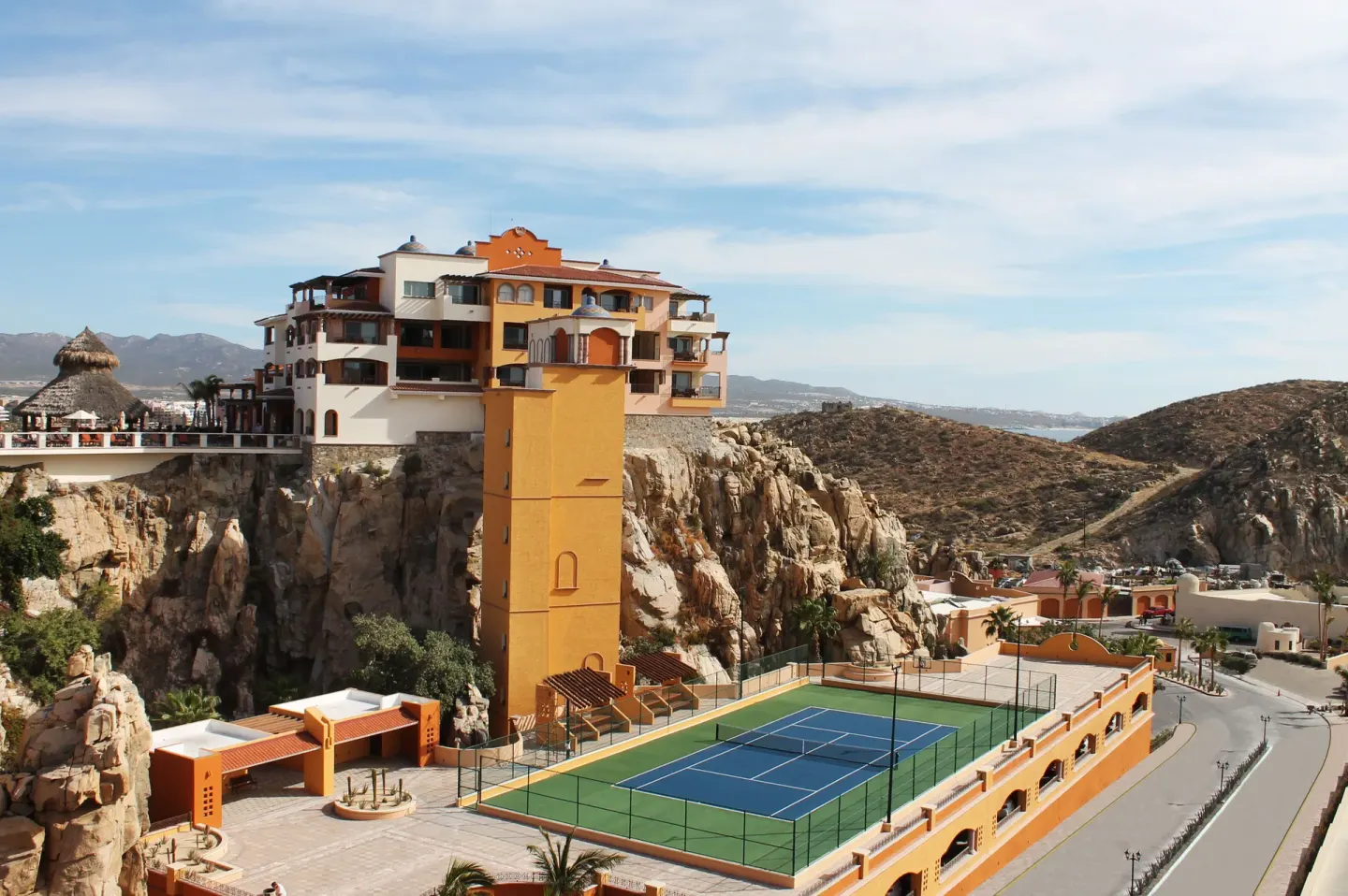 Tennis court and hillside buildings at Playa Grande Resort & Grand Spa.