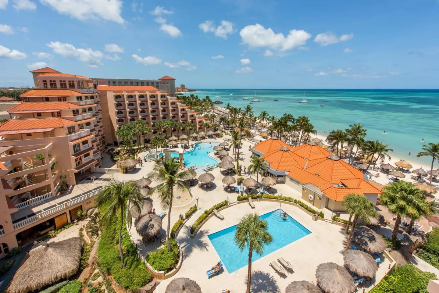 Aerial view of pools, beach, and ocean at Playa Linda Beach Resort.