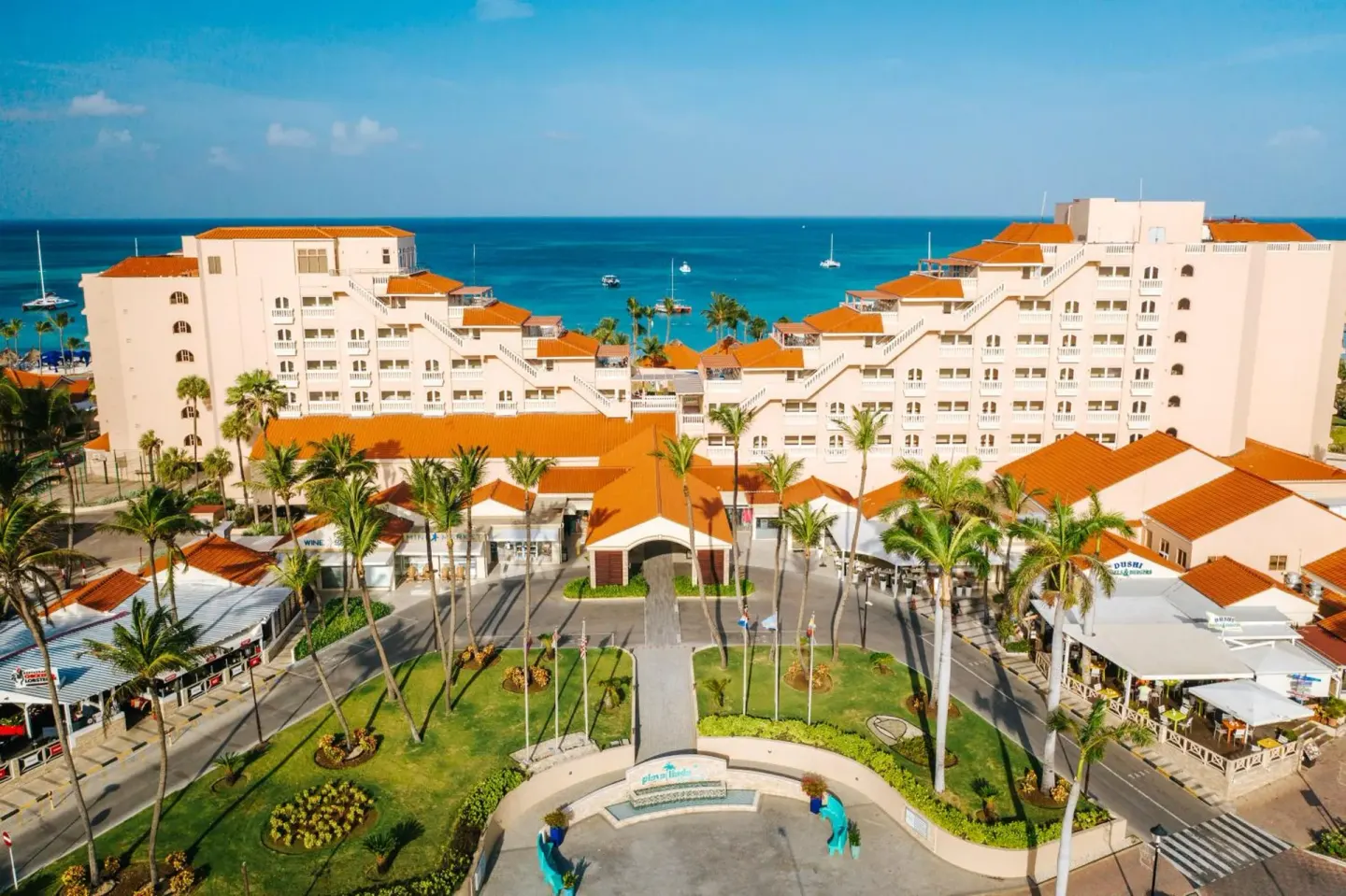 Aerial view of resort buildings, palms, and the sea at Playa Linda Beach Resort.
