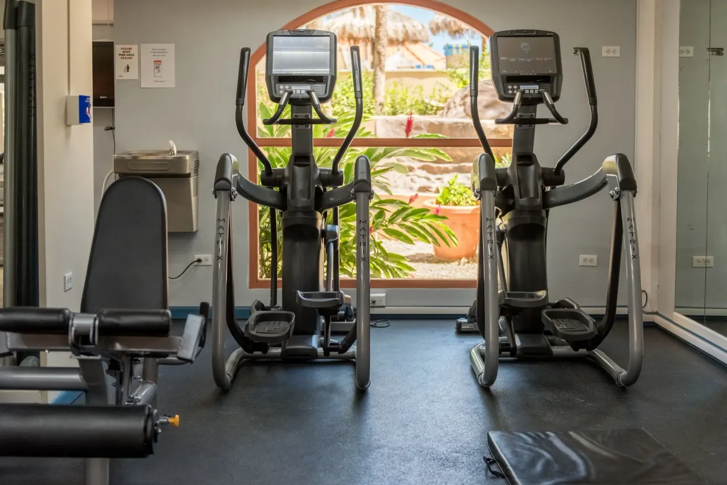 Fitness room with cardio machines and mirrors at Playa Linda Beach Resort.