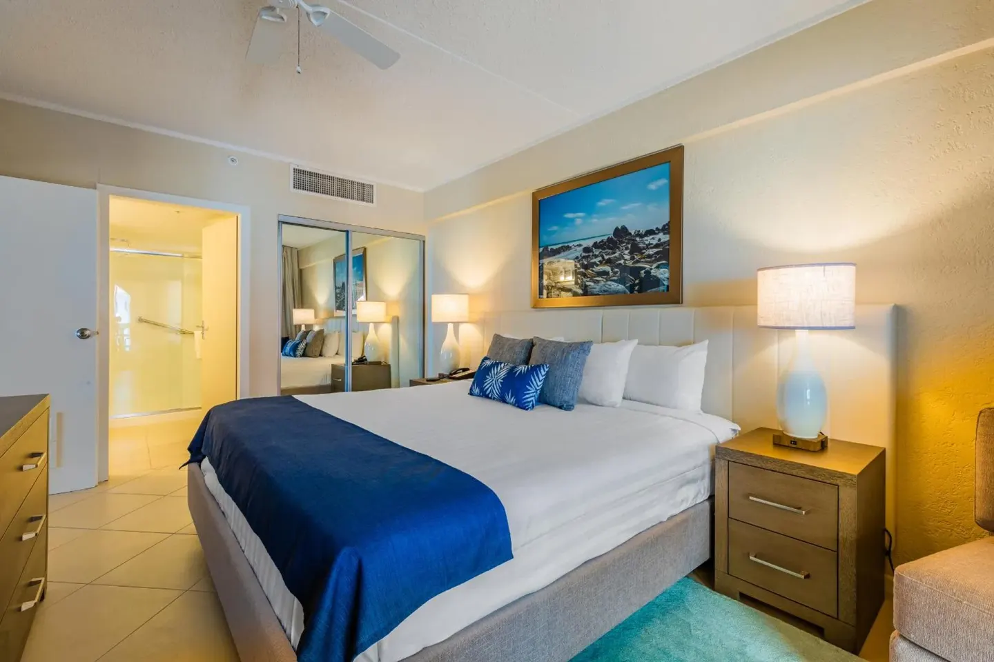 King bed guest room with blue accents at Playa Linda Beach Resort.