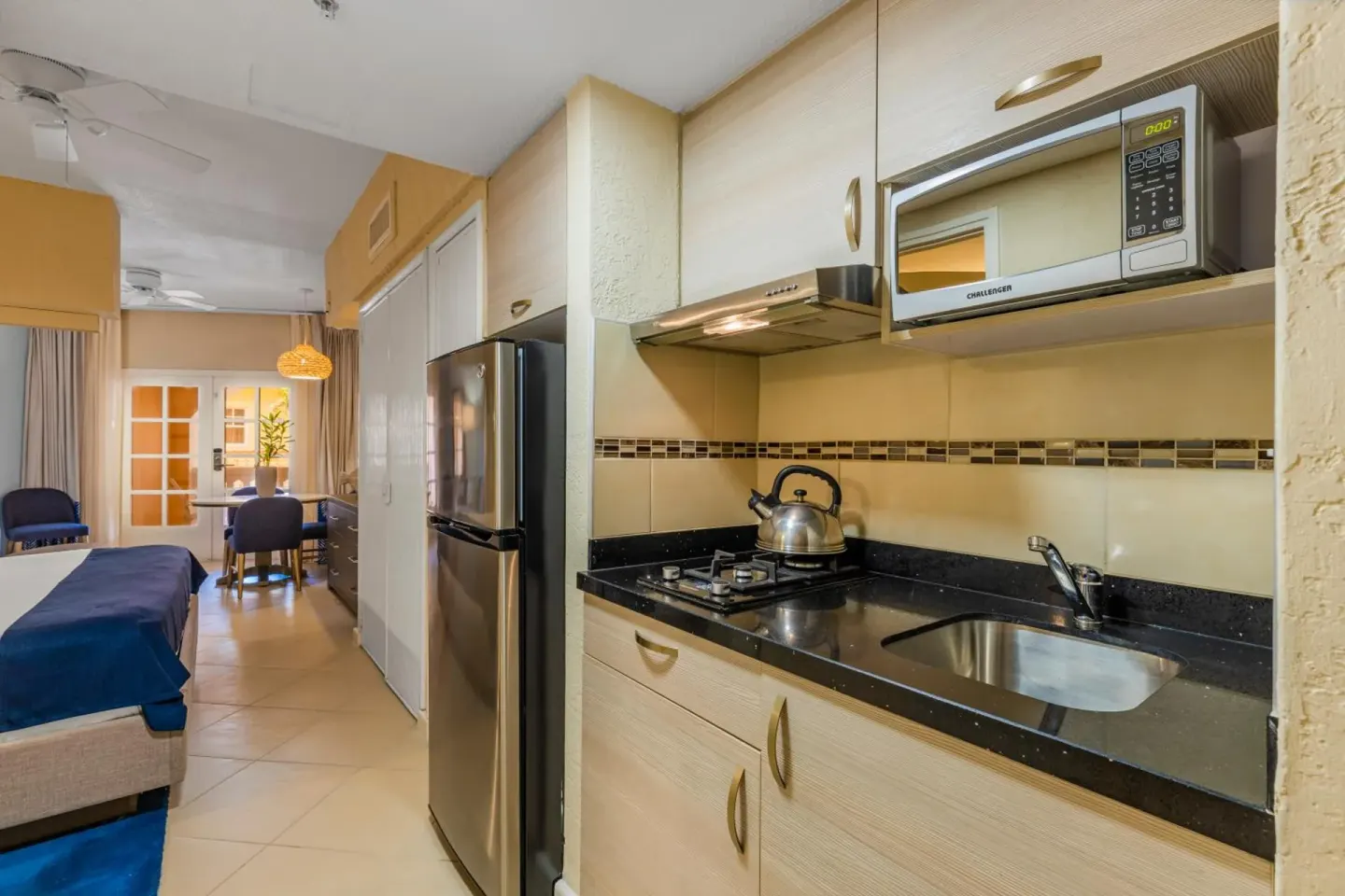 Guest room kitchenette with sink, stovetop, microwave, and refrigerator at Playa Linda Beach Resort.