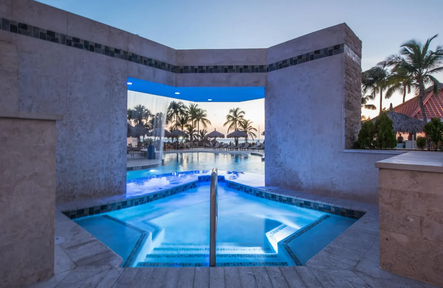 Illuminated hot tub or spa pool with steps near the main pool at Playa Linda Beach Resort.