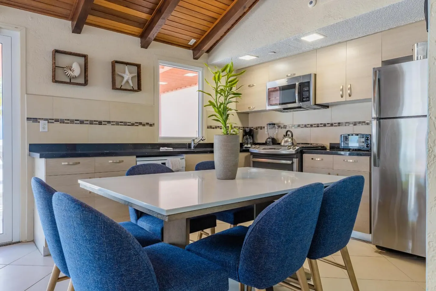 Kitchen and dining area with blue chairs at Playa Linda Beach Resort.