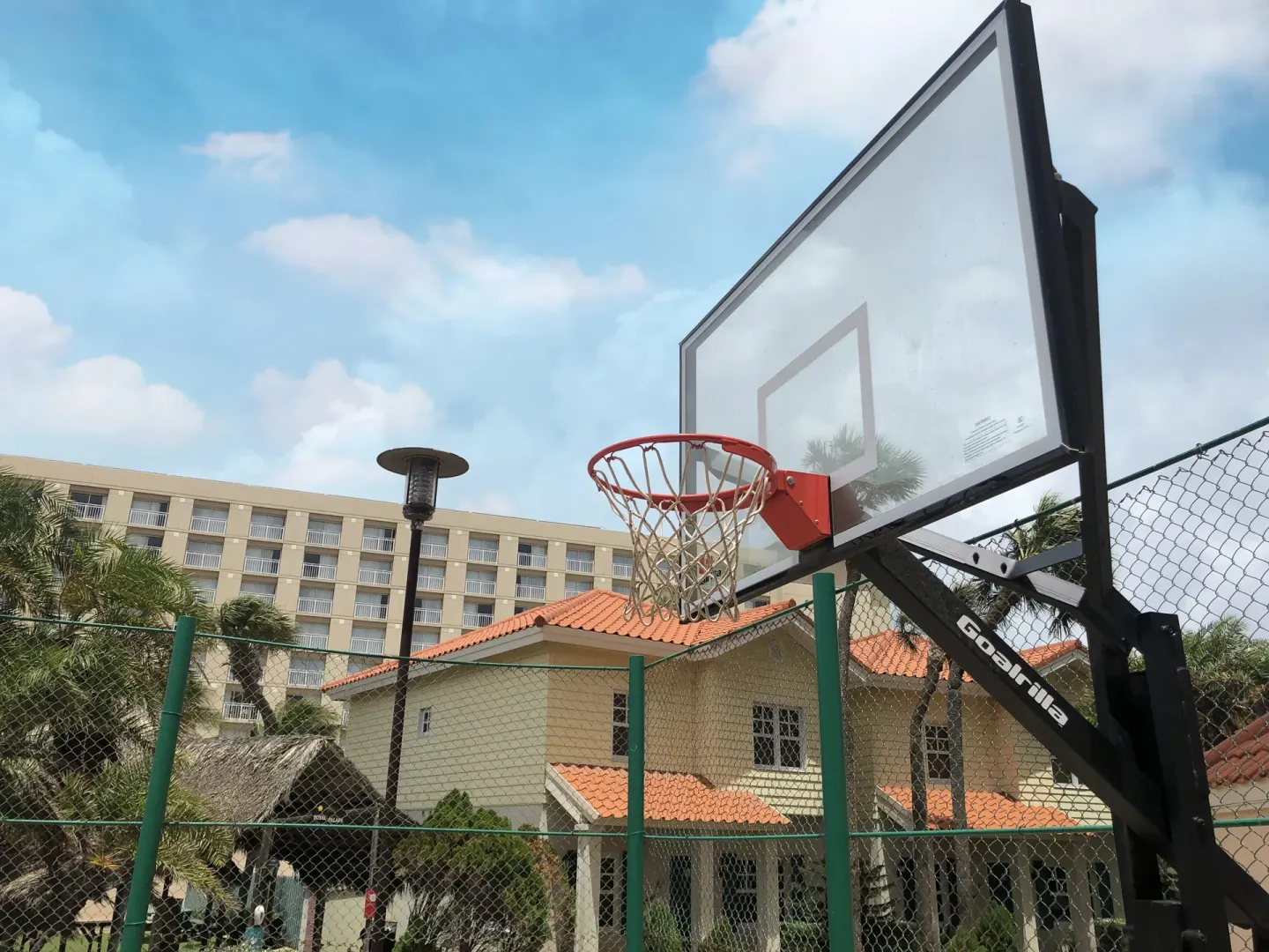 Outdoor basketball hoop and fenced court area at Playa Linda Beach Resort.