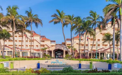 Palm-lined entrance and resort facade at Playa Linda Beach Resort.