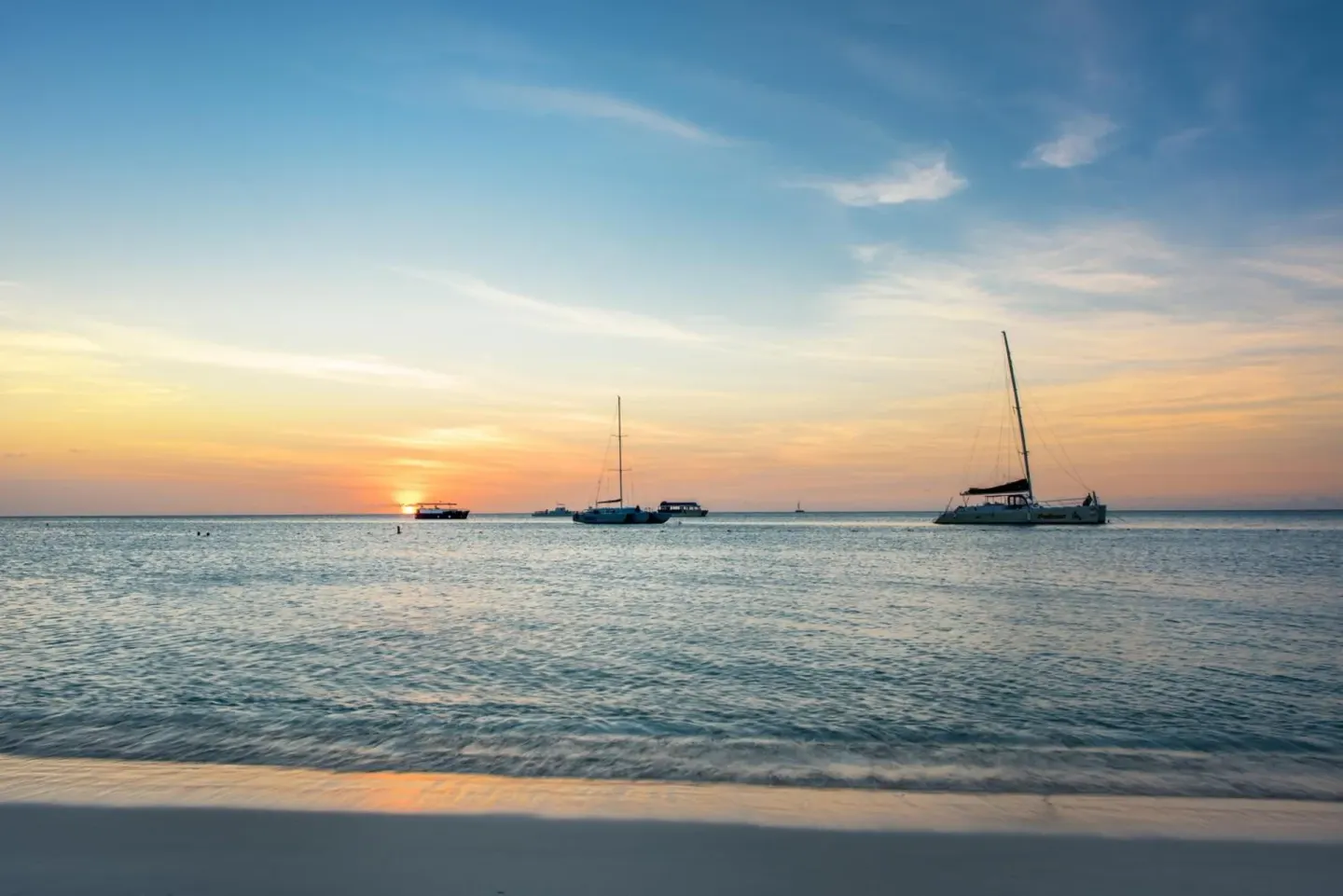 Sunset beach scene with sailboats near Playa Linda Beach Resort.
