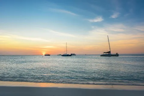 Sunset beach scene with sailboats near Playa Linda Beach Resort.