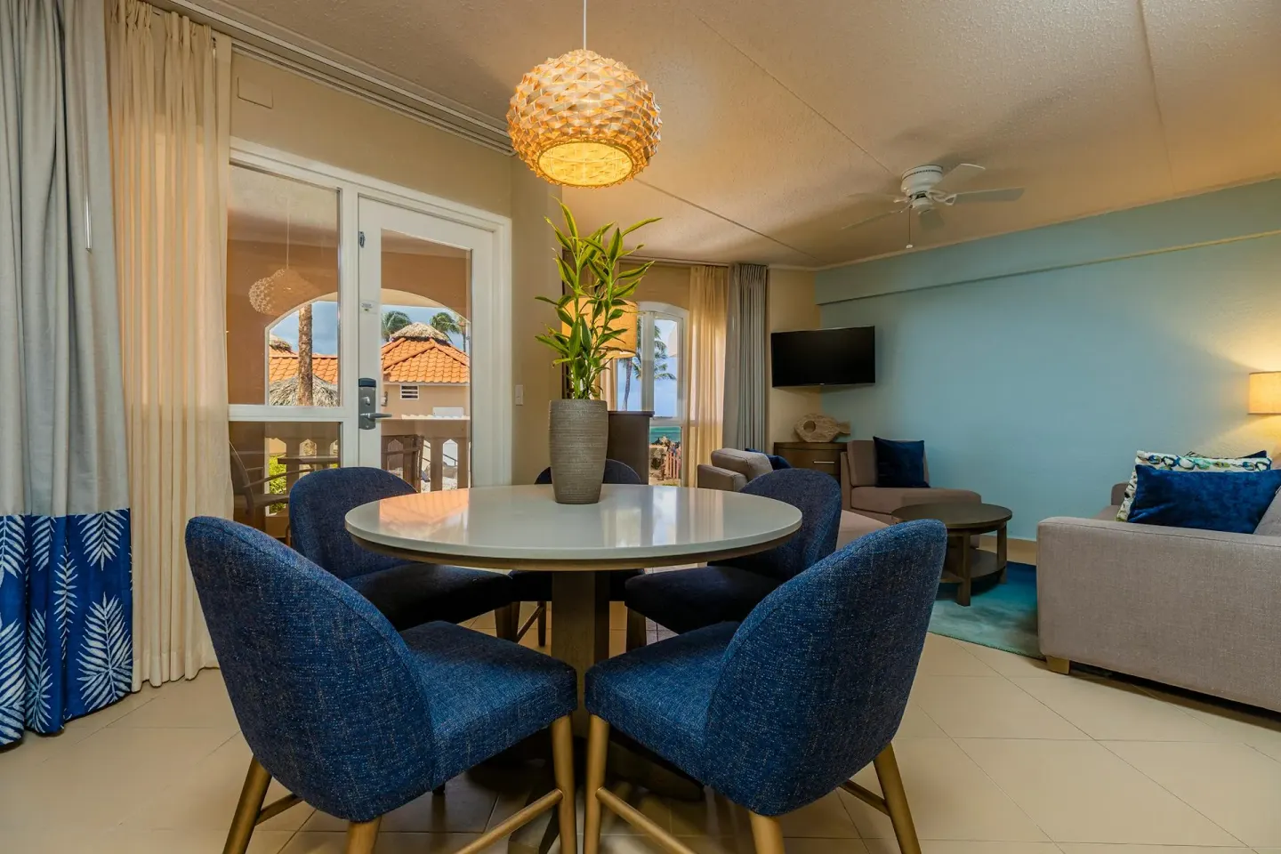 Dining table for four flowing into the living area in the One Bedroom Suite at Playa Linda Beach Resort.