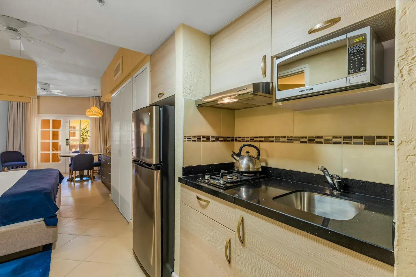 Studio Suite kitchenette with gas cooktop, microwave and full refrigerator at Playa Linda Beach Resort.
