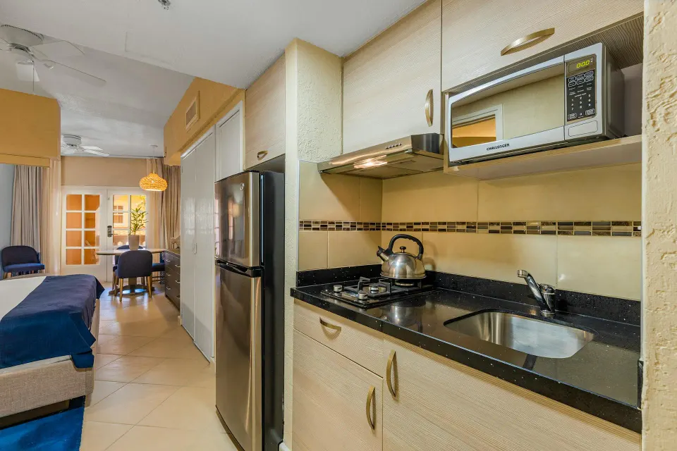 Studio Suite kitchenette with gas cooktop, microwave and full refrigerator at Playa Linda Beach Resort.