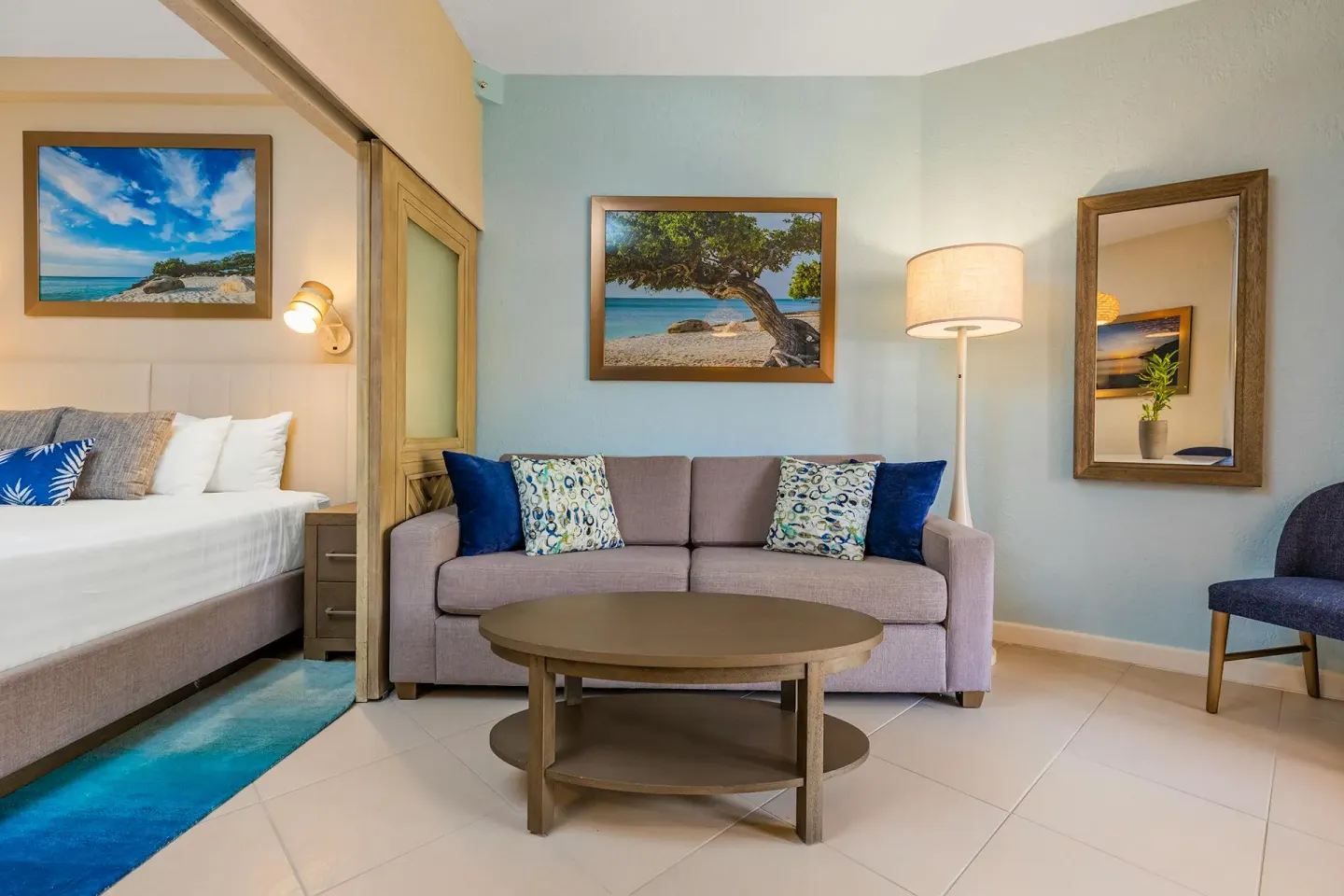 Studio Suite sitting area with sofa and coffee table beside the bed at Playa Linda Beach Resort.
