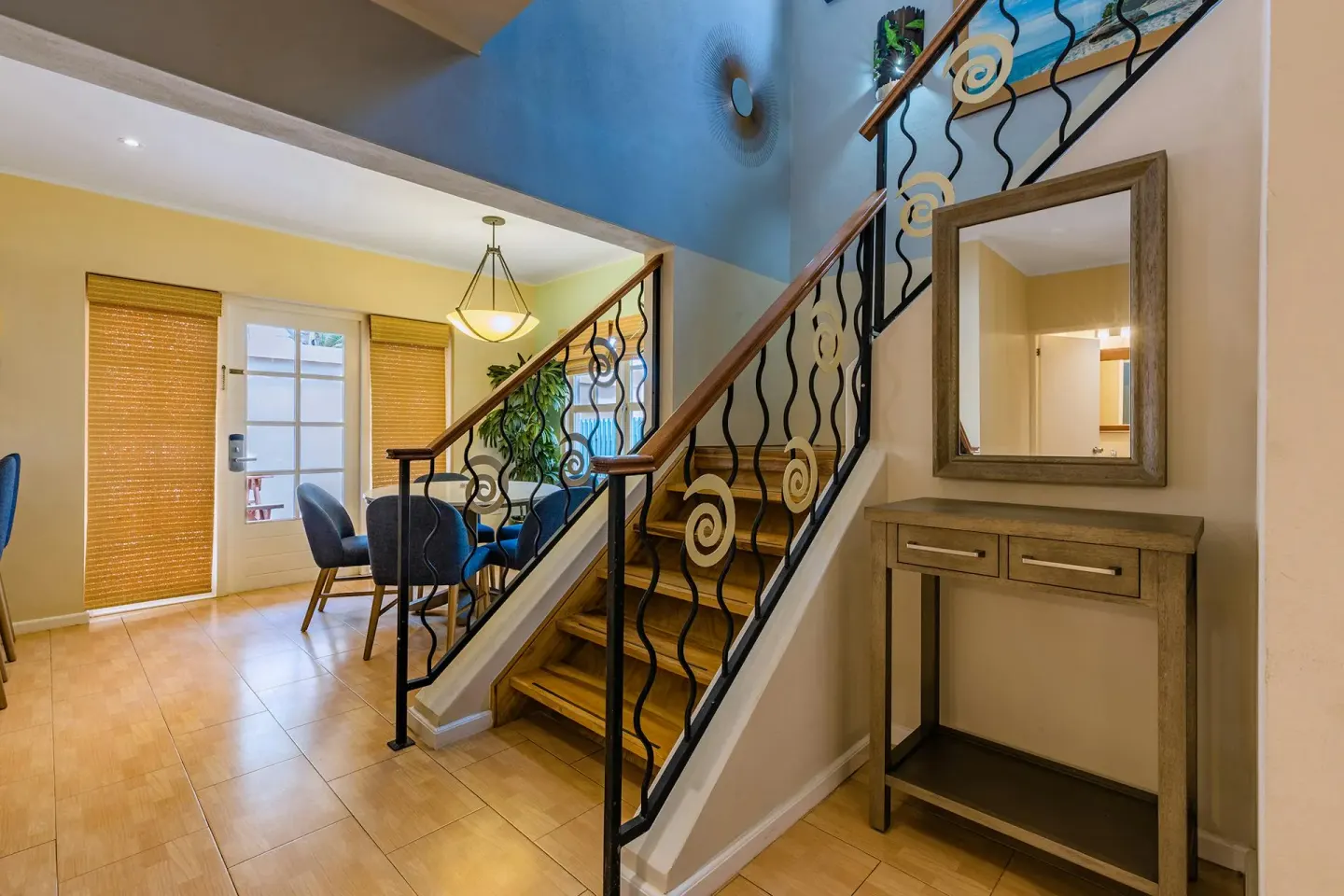 Two-story entry with wood staircase and dining nook in the Townhouse Three Bedroom at Playa Linda Beach Resort.
