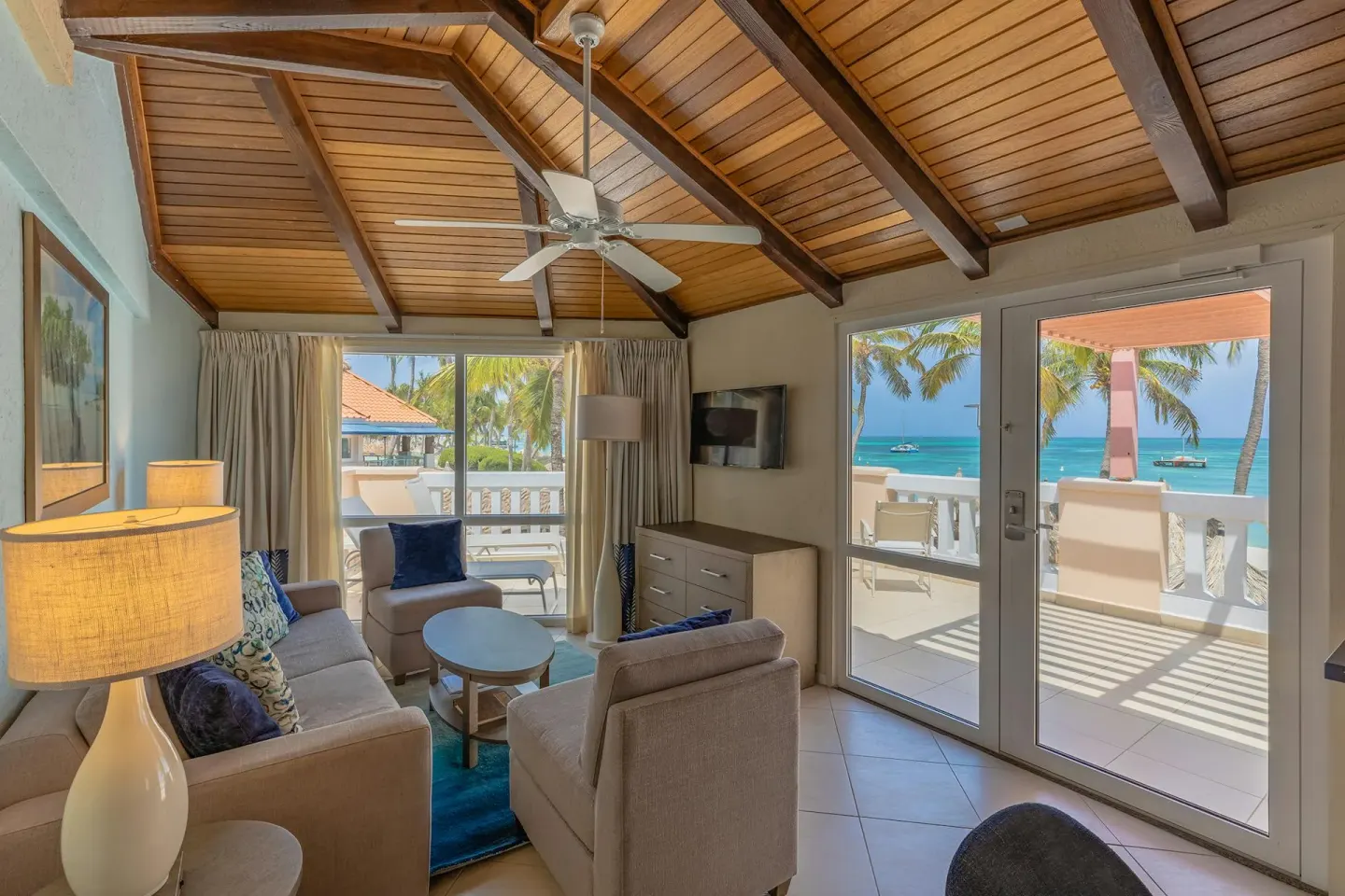 Vaulted wood-beam living room opening to an oceanfront terrace in the Two Bedroom Suite at Playa Linda Beach Resort.