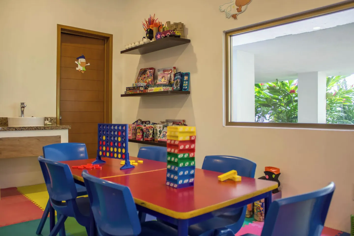 Children's playroom with games and blue chairs at Plaza Pelicanos Club Beach Resort.