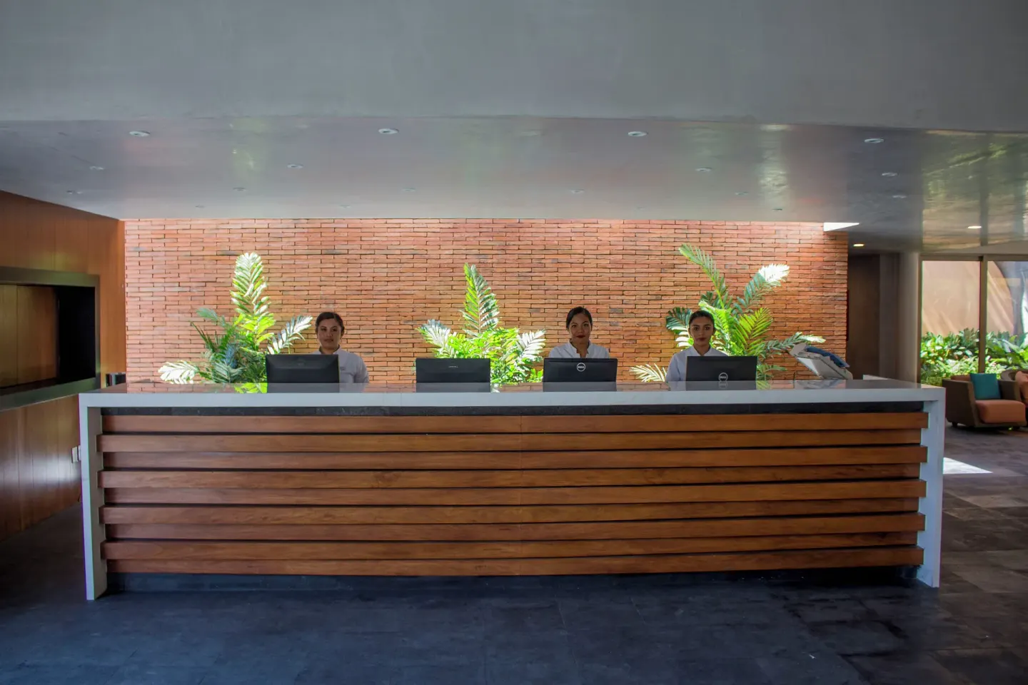 Front desk with three staff members in the lobby of Plaza Pelicanos Club Beach Resort.