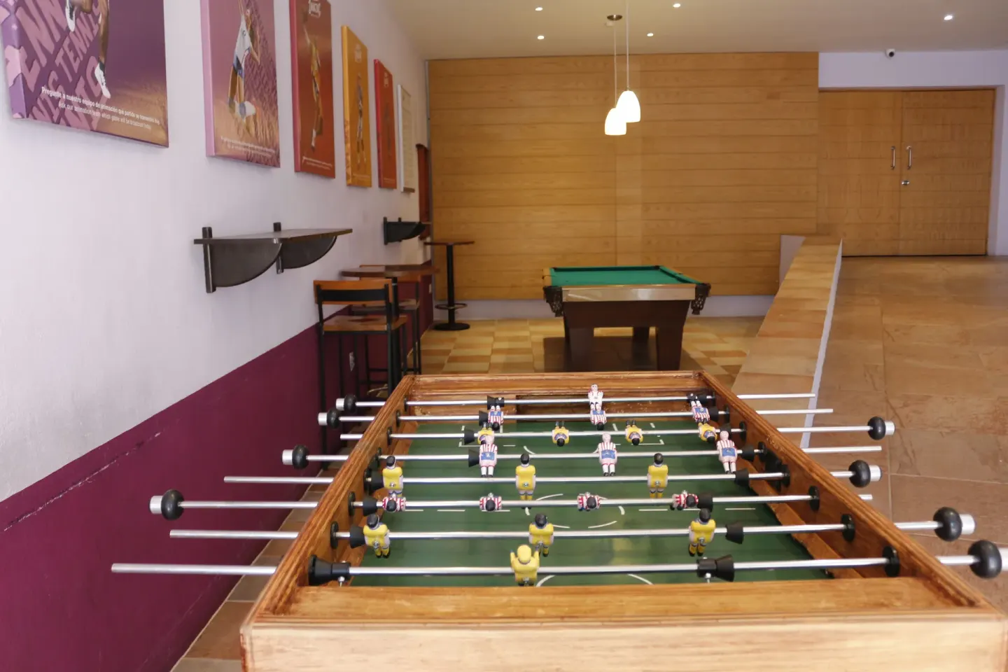A foosball table and pool table in a game area at Plaza Pelicanos Club Beach Resort.