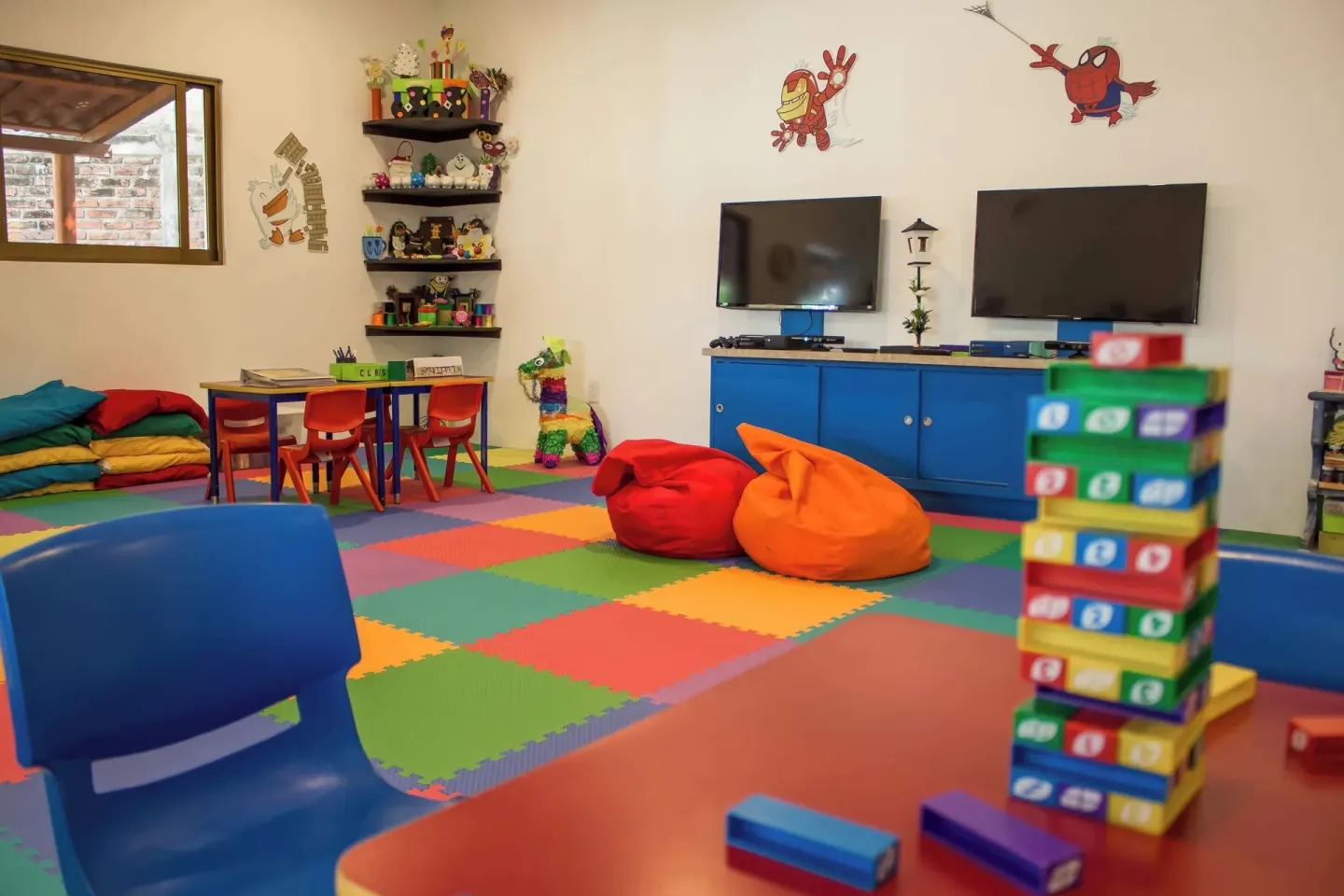 Kids' club playroom with beanbags, screens, and toys at Plaza Pelicanos Club Beach Resort.